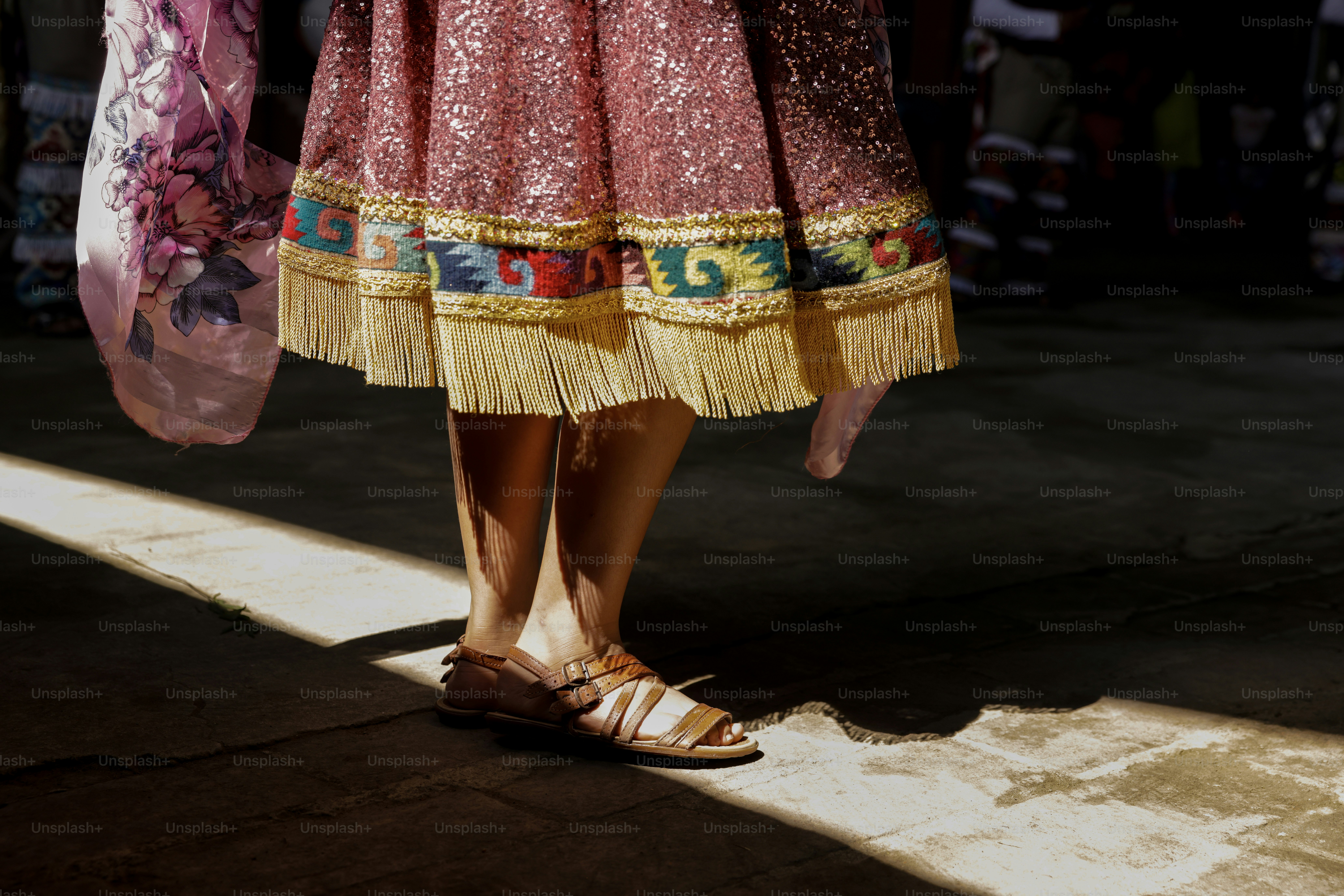 人は装飾されたスカートとサンダルを履いています。