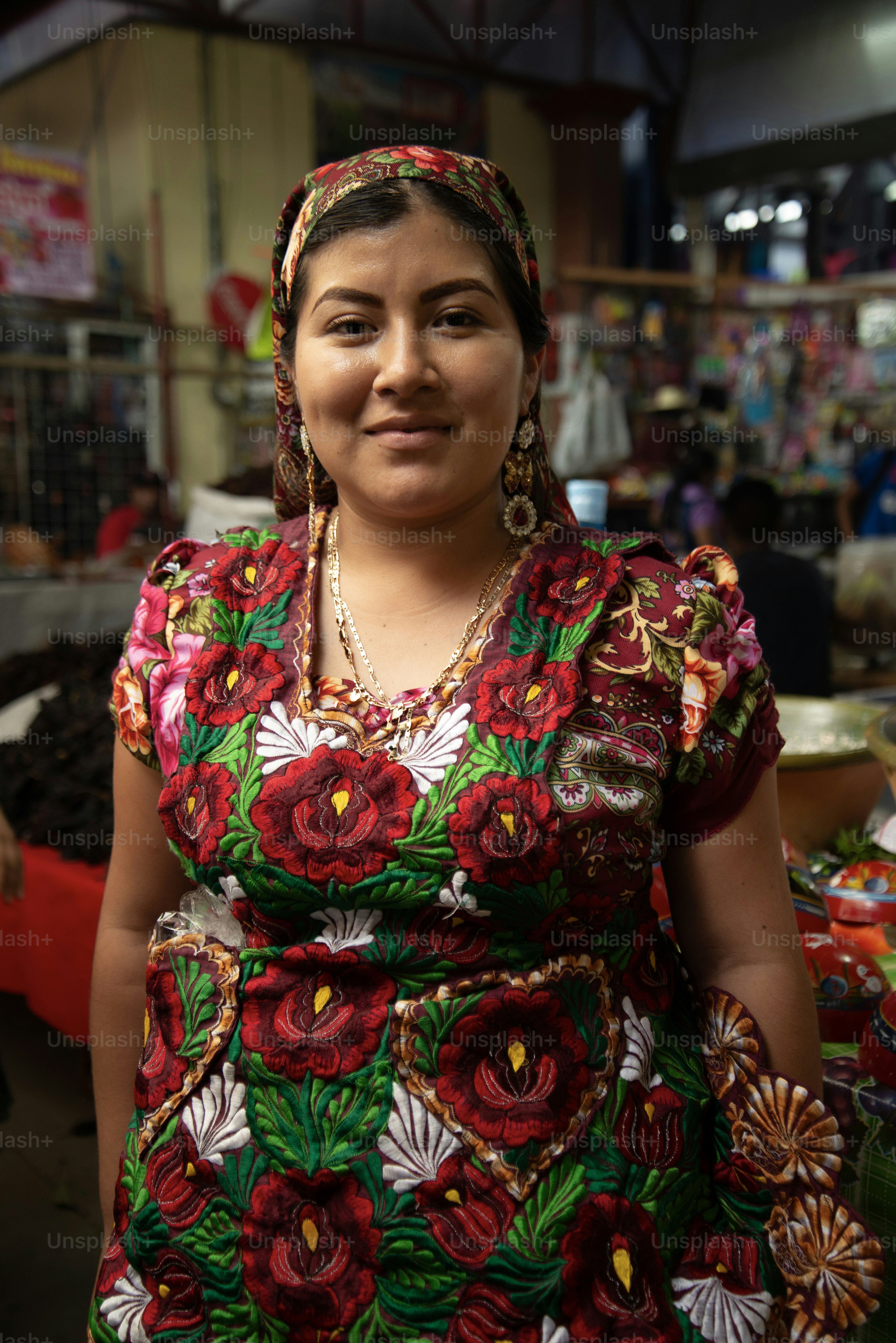 Uma mulher sorri em roupas bordadas tradicionais.