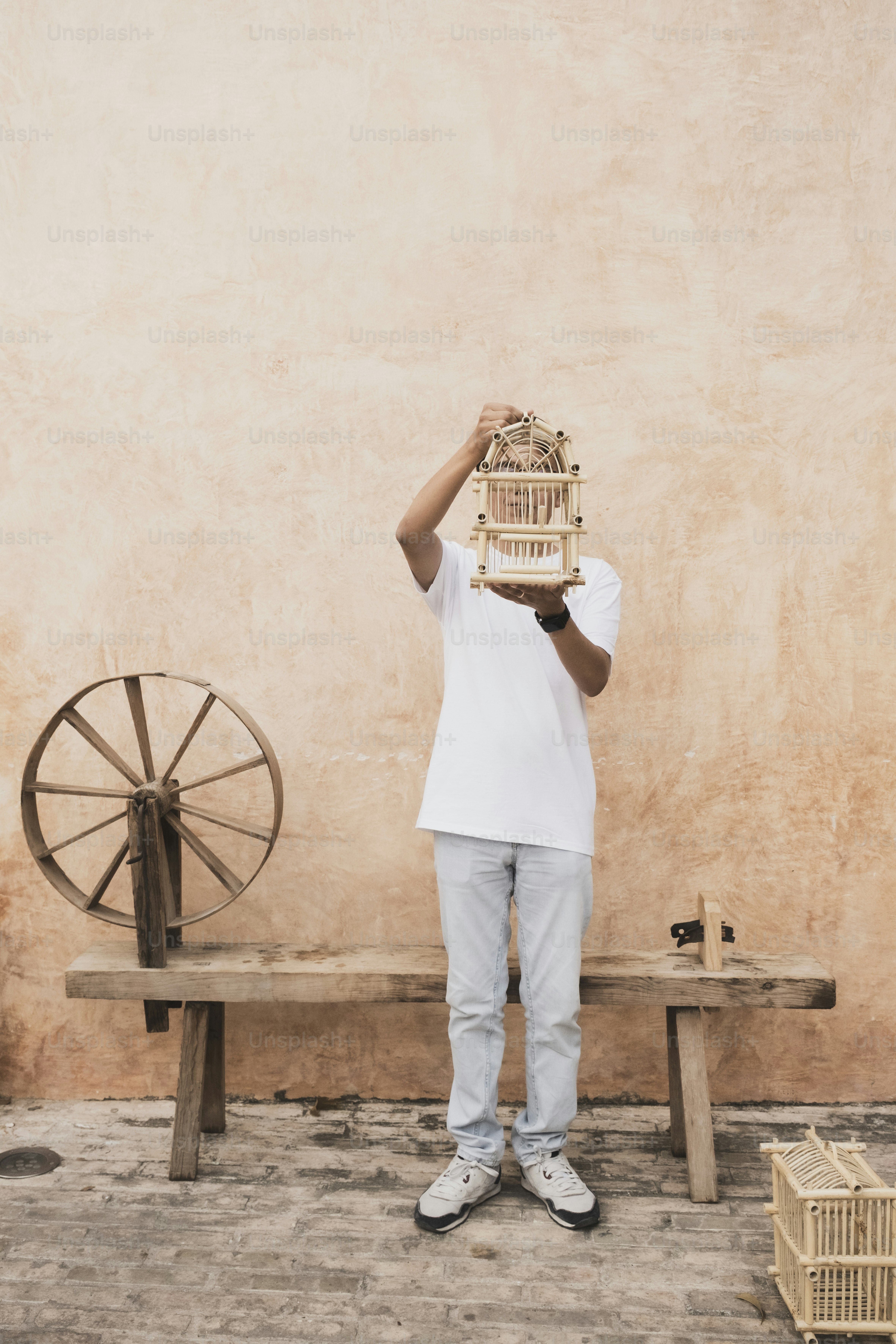 男は鳥かごを顔の前に持っています。