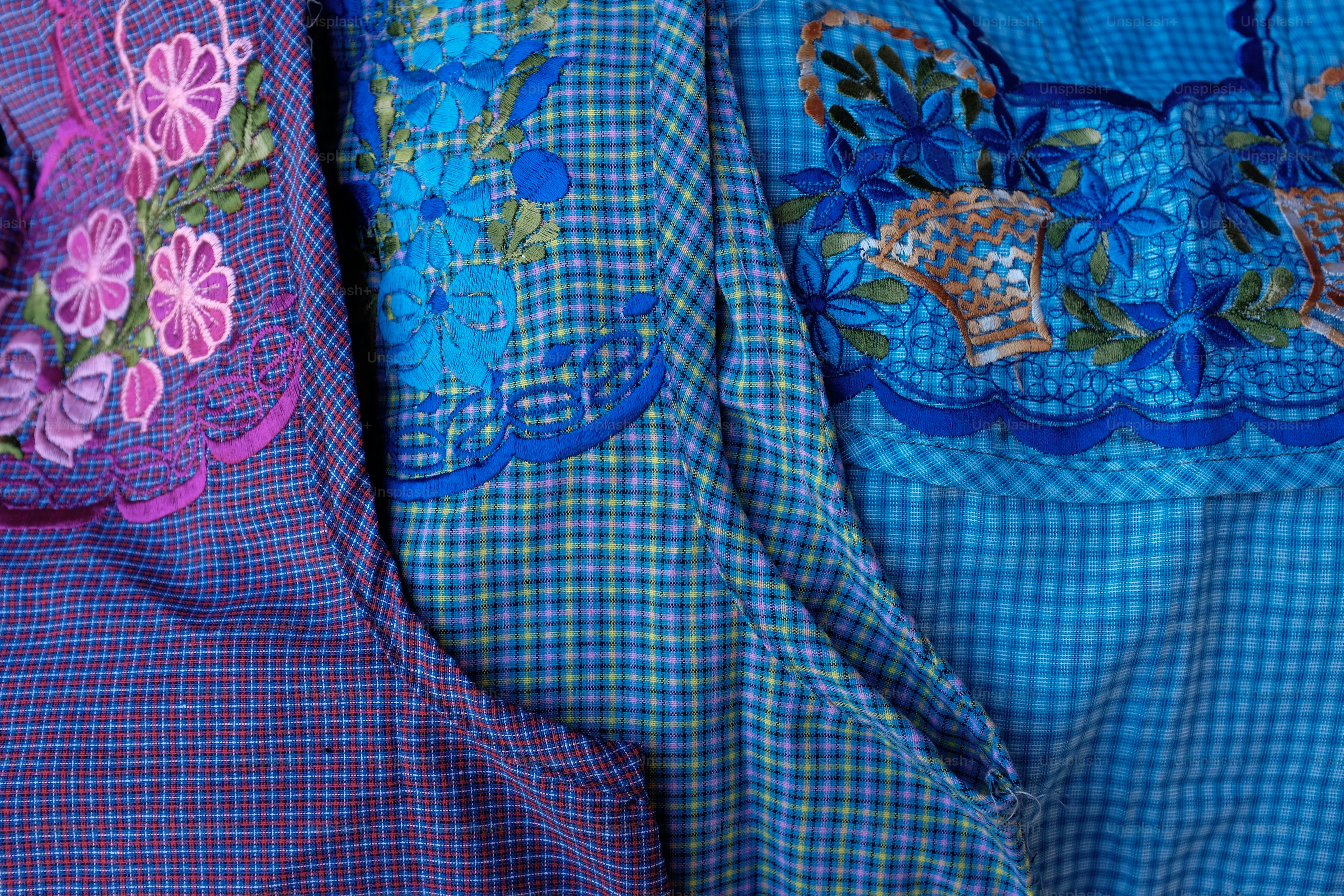 Colorful embroidered fabrics display beautiful floral designs.