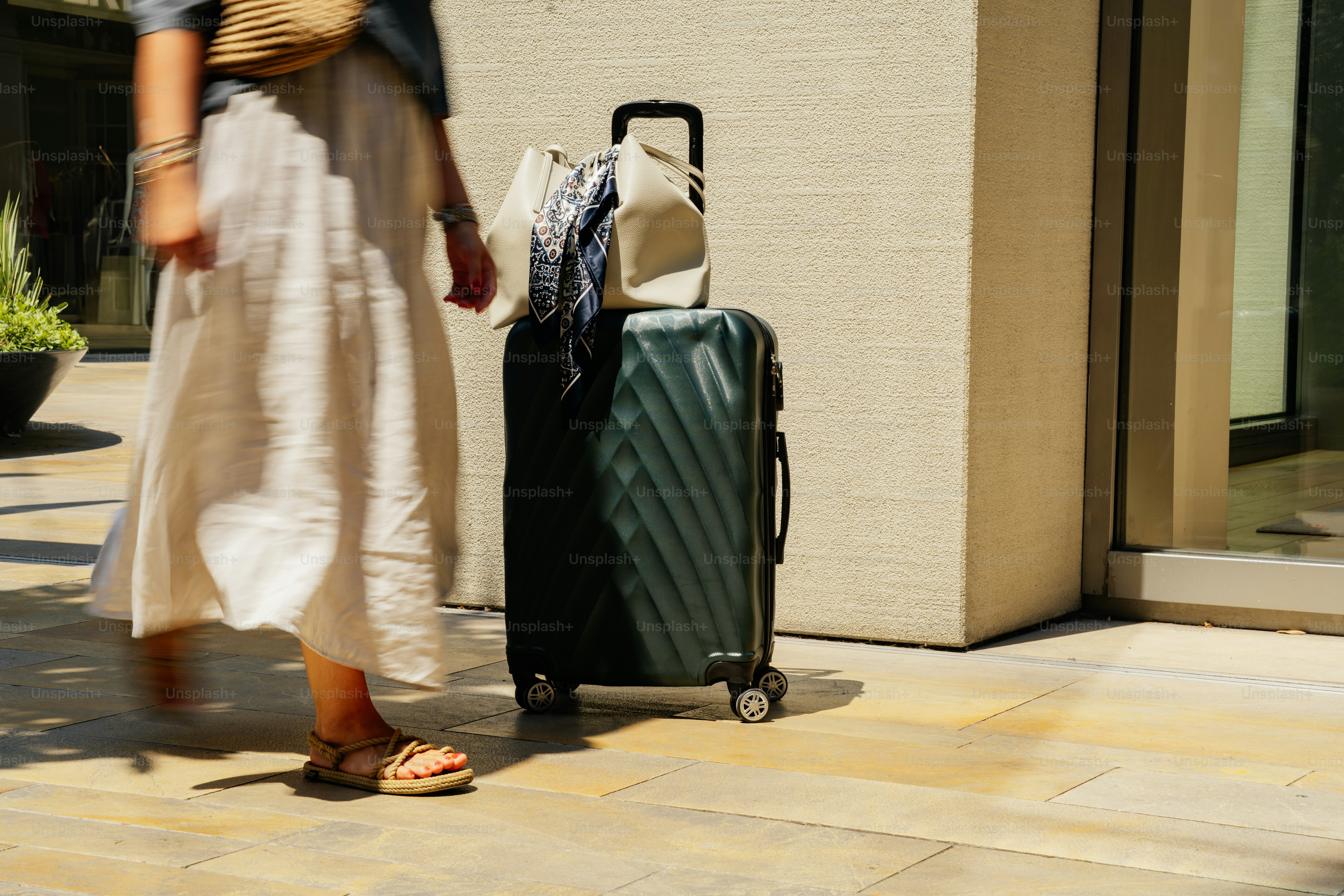 A person walks near a suitcase.