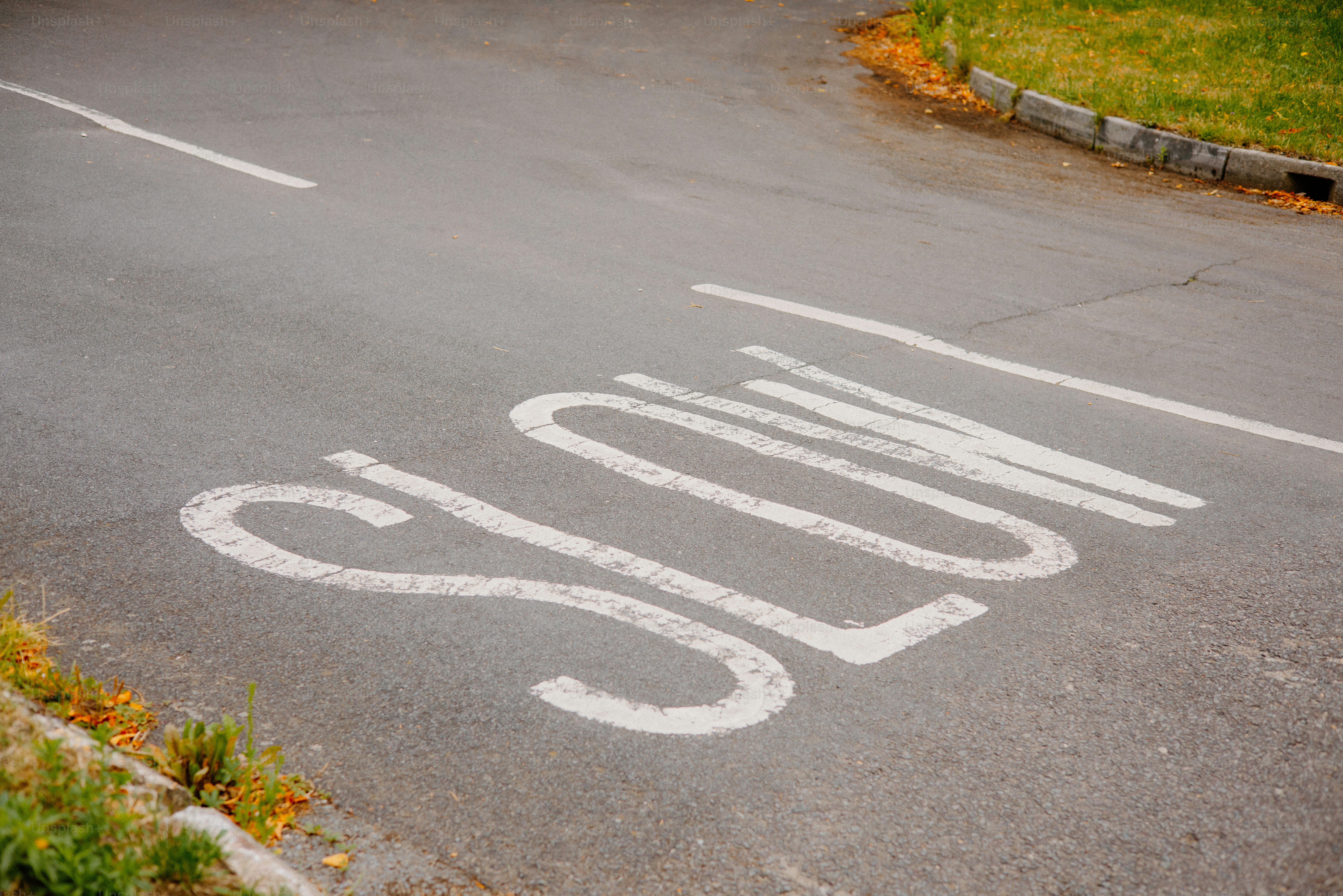 Auf dem Bürgersteig einer Straße ist das Wort "langsam" zu lesen.