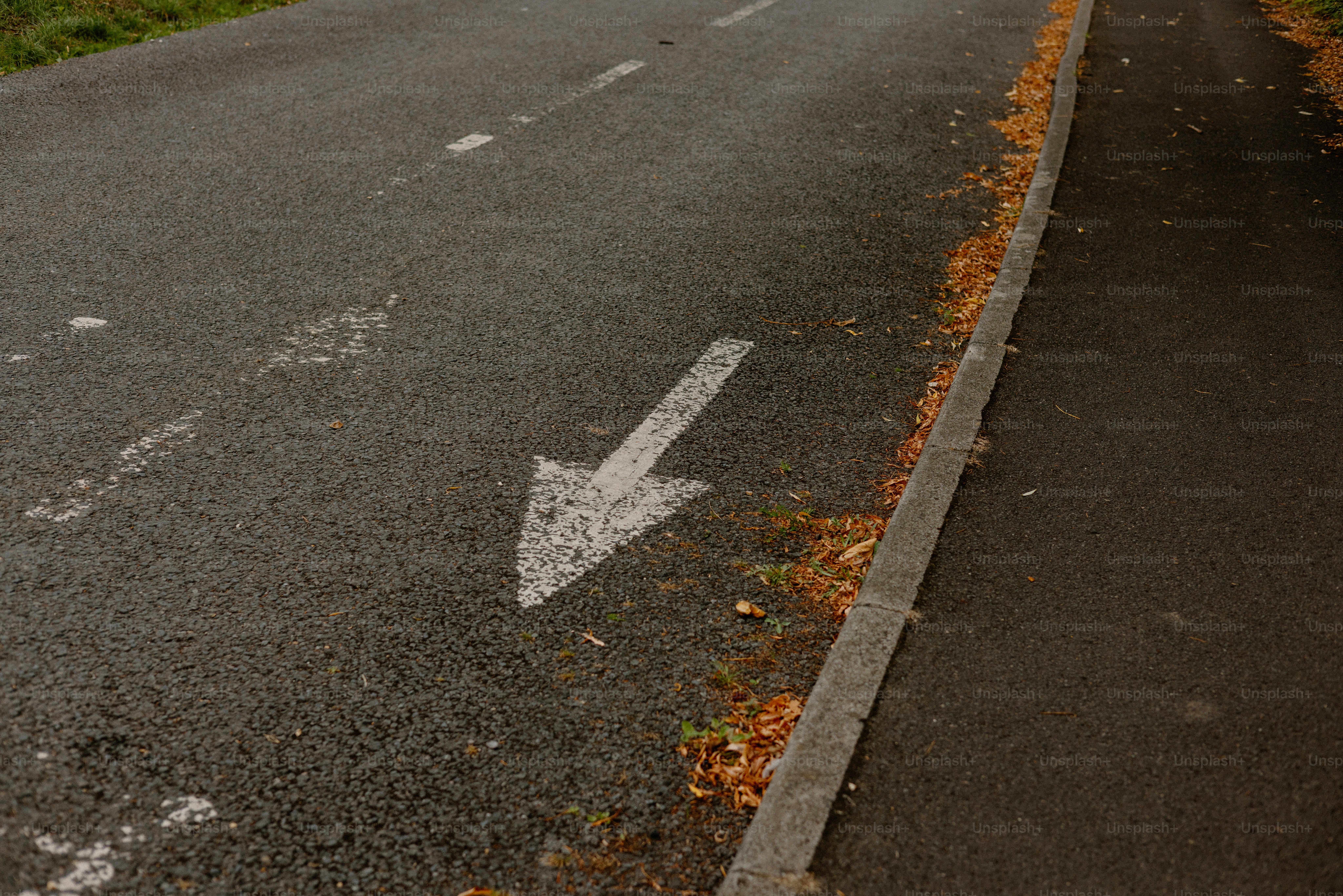 La flèche indique une direction sur une route goudronnée.