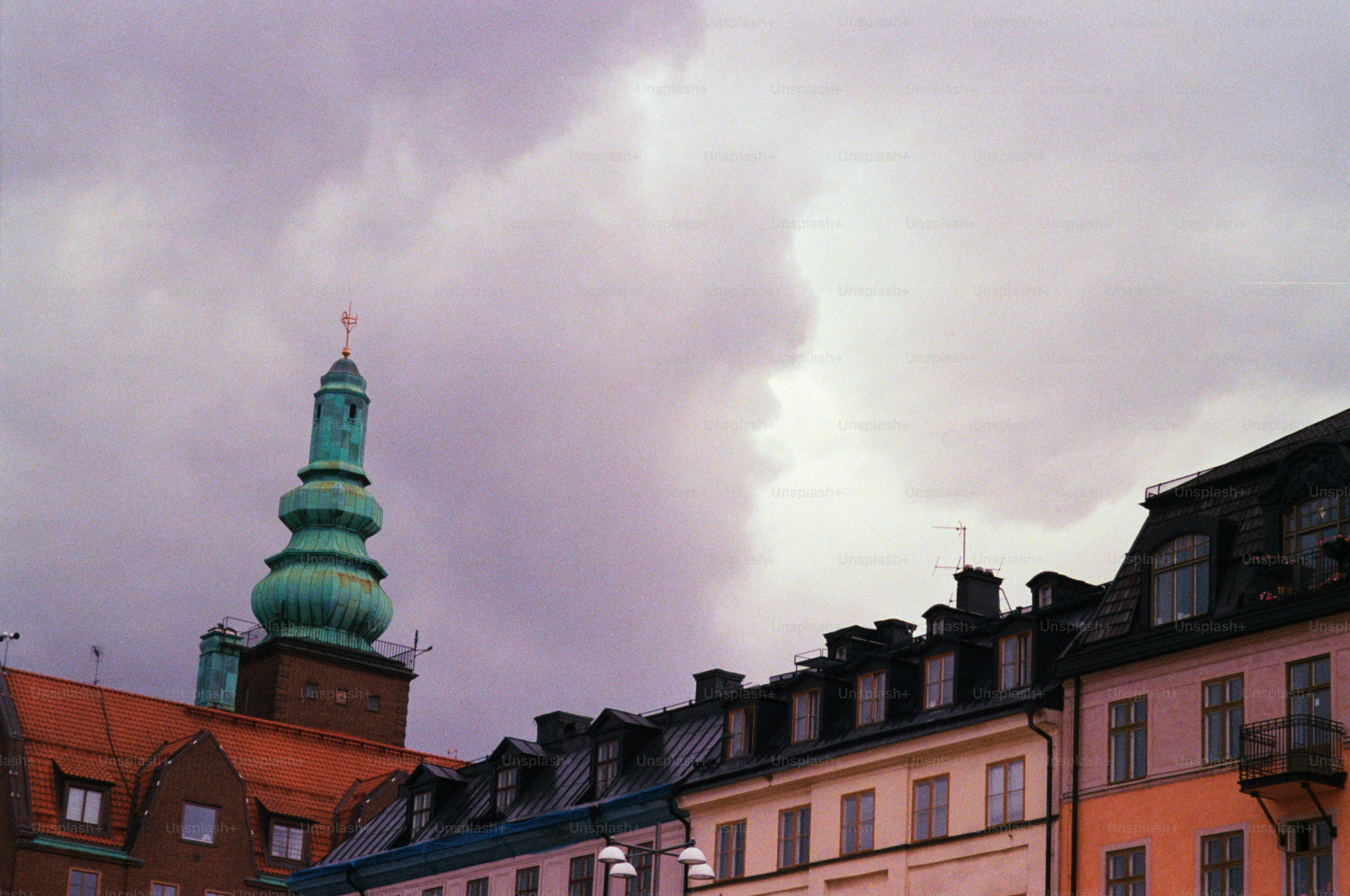 Gebäude ragen unter einem dramatischen, wolkenverhangenen Himmel.