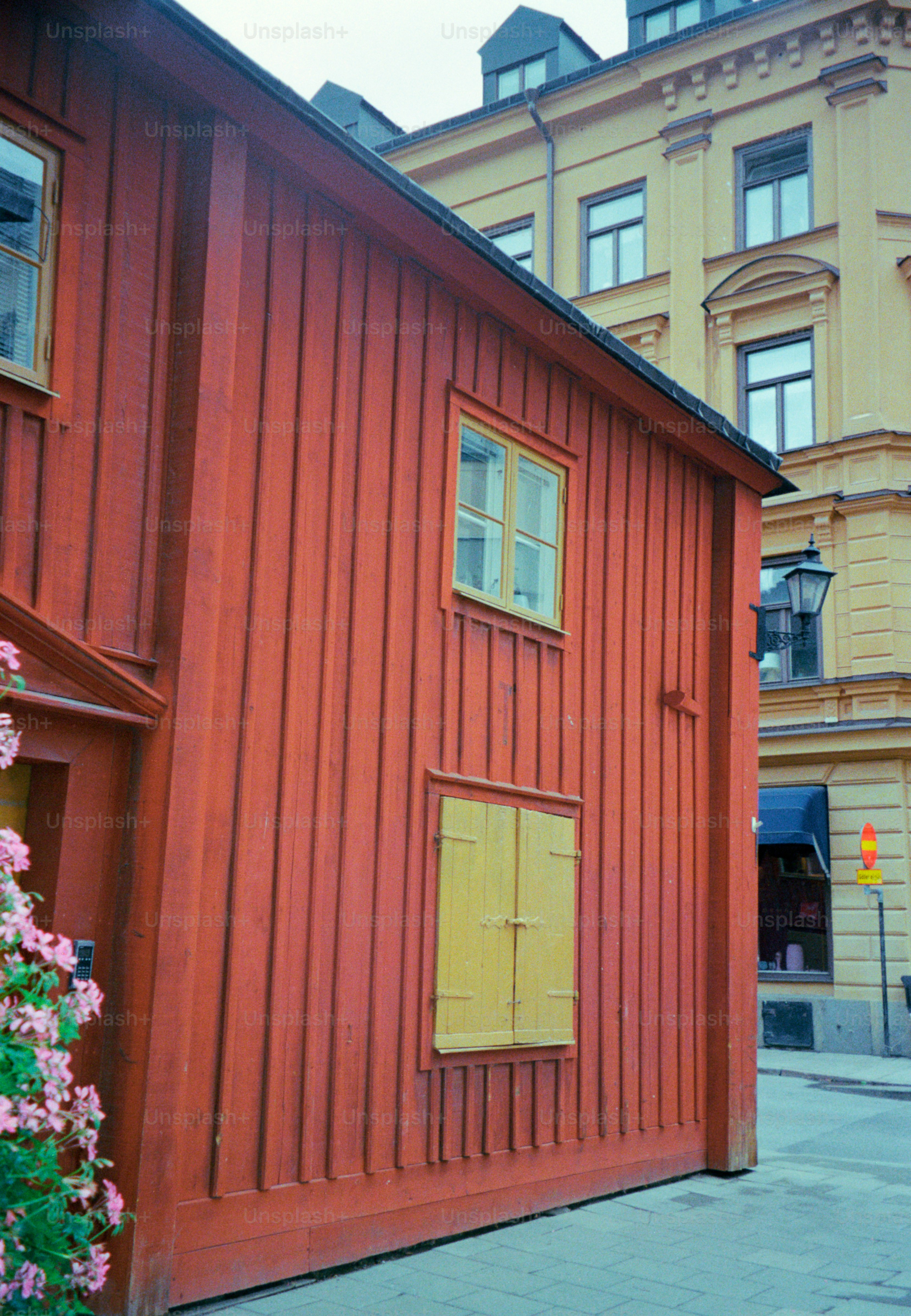 Red wooden building stands next to a yellow building.