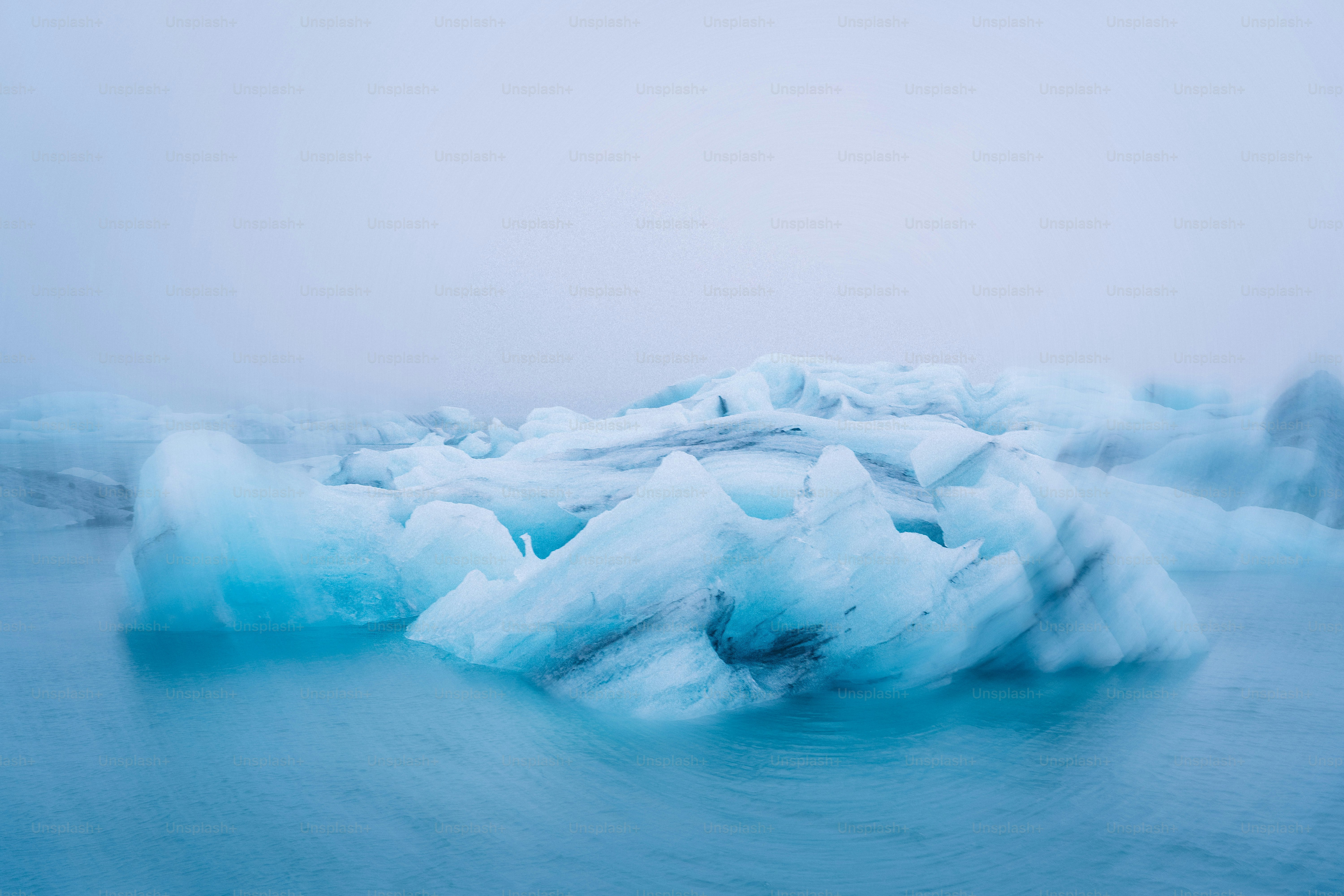 Iceberg floats in the cold, misty ocean.
