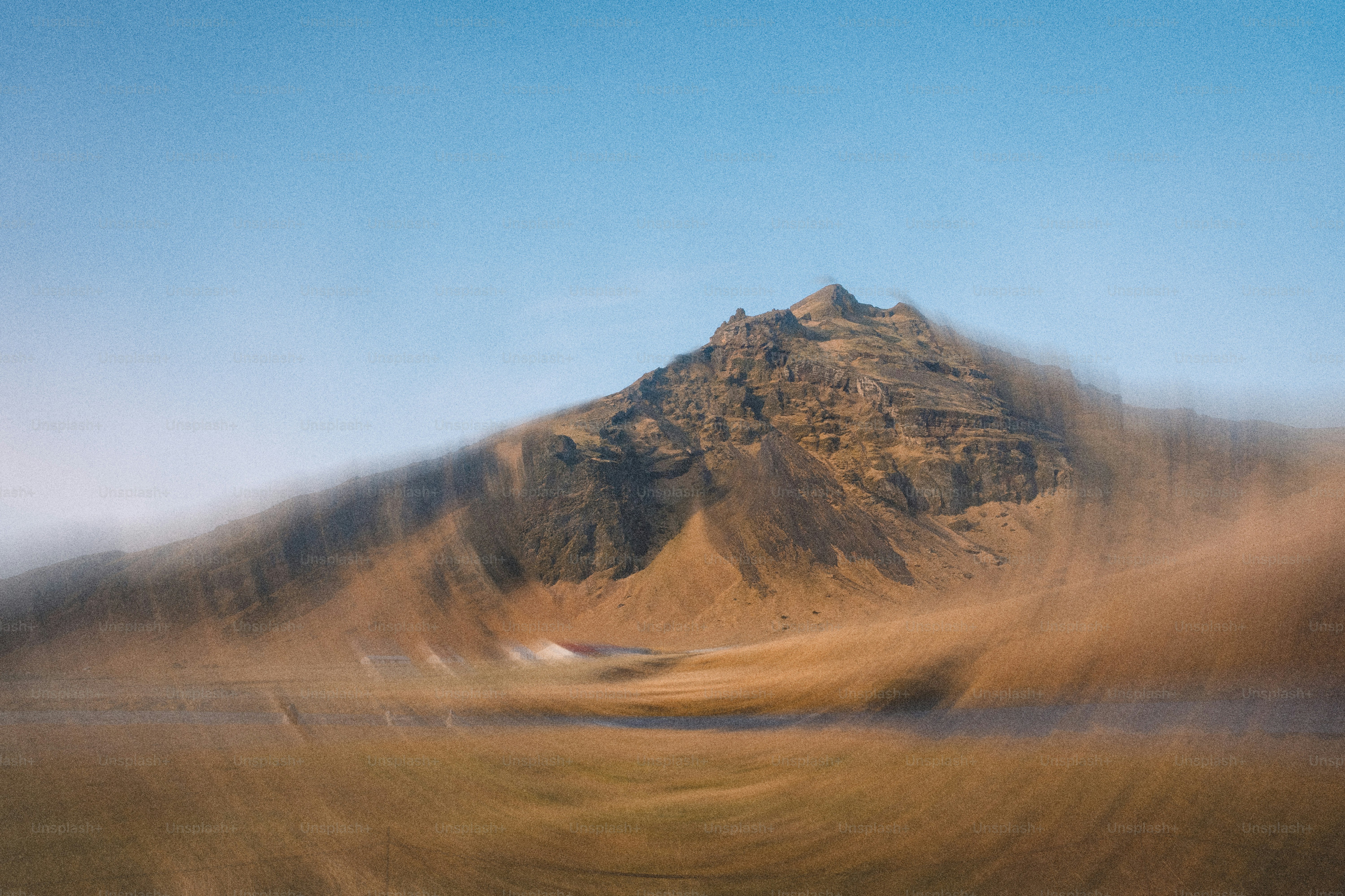 Motion-blurred mountain with blue sky background.