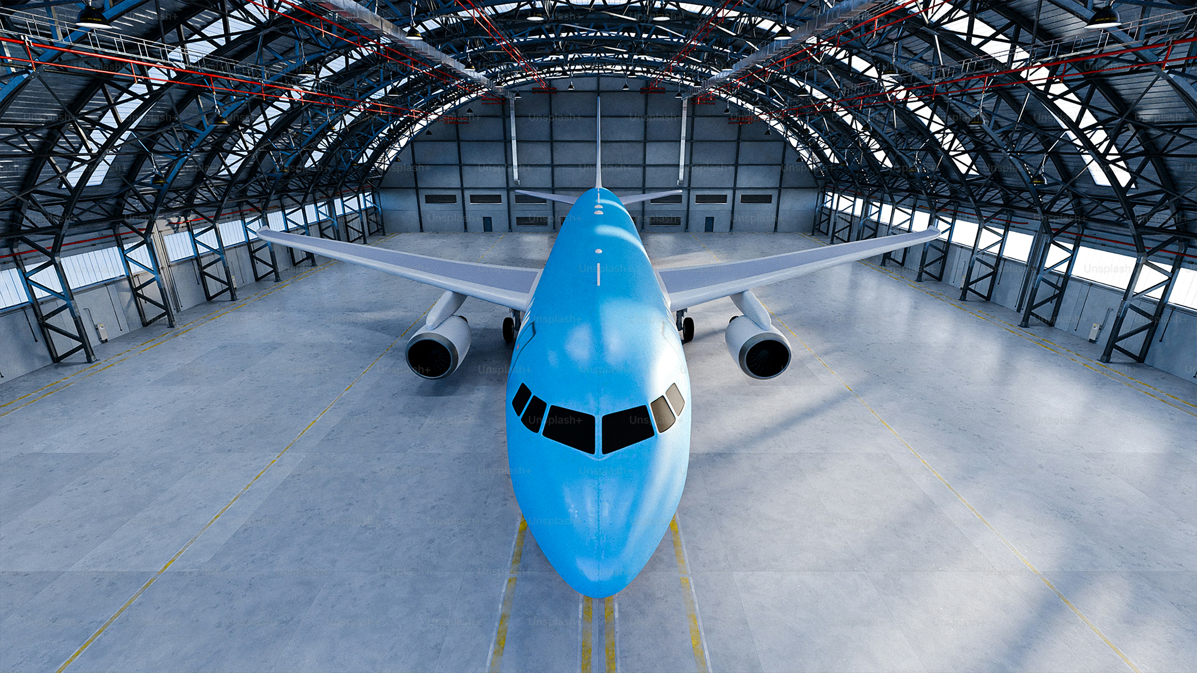 A blue airplane is parked inside a hangar.