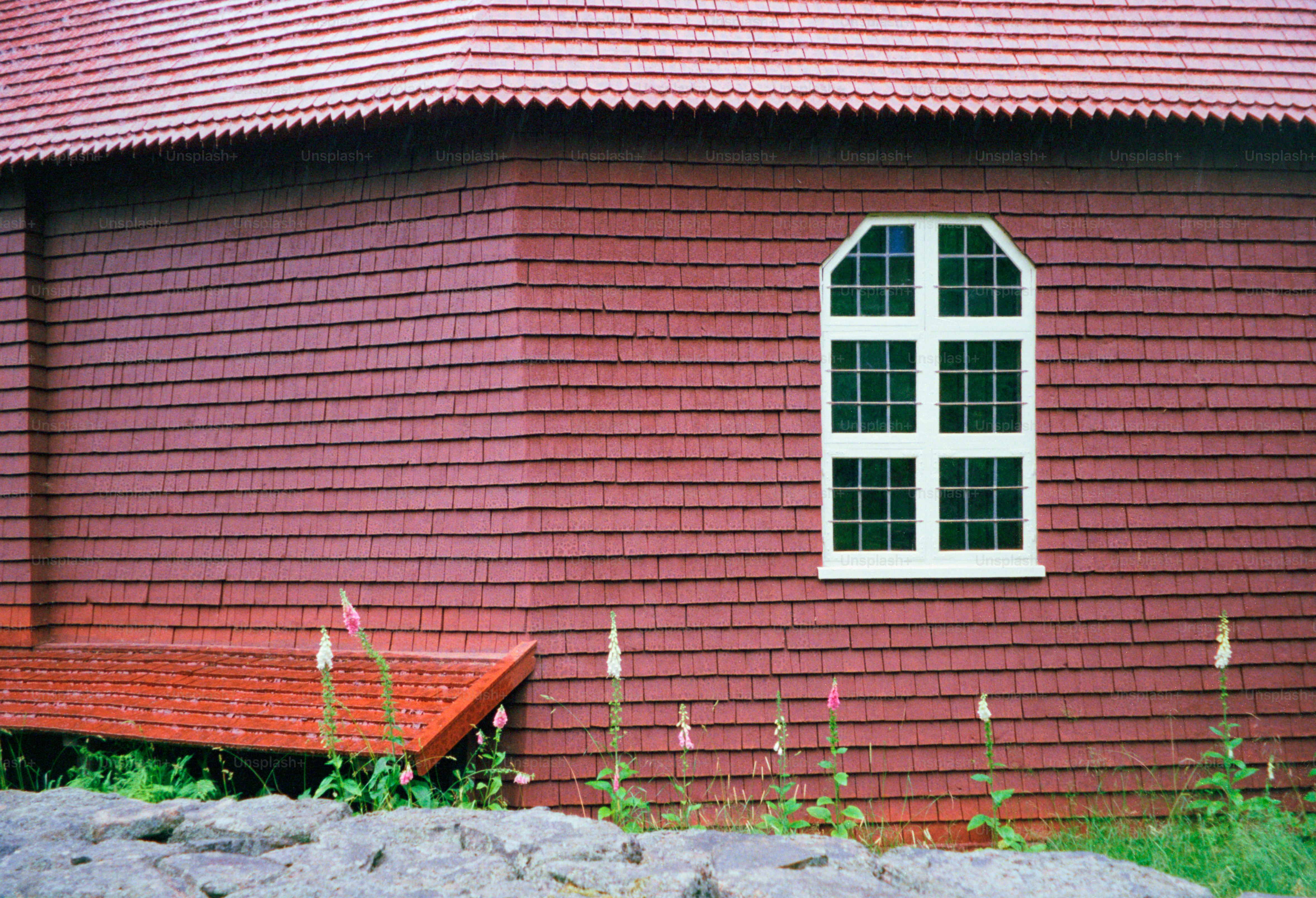 Rotes Gebäude mit Fenster und rotem Dach.