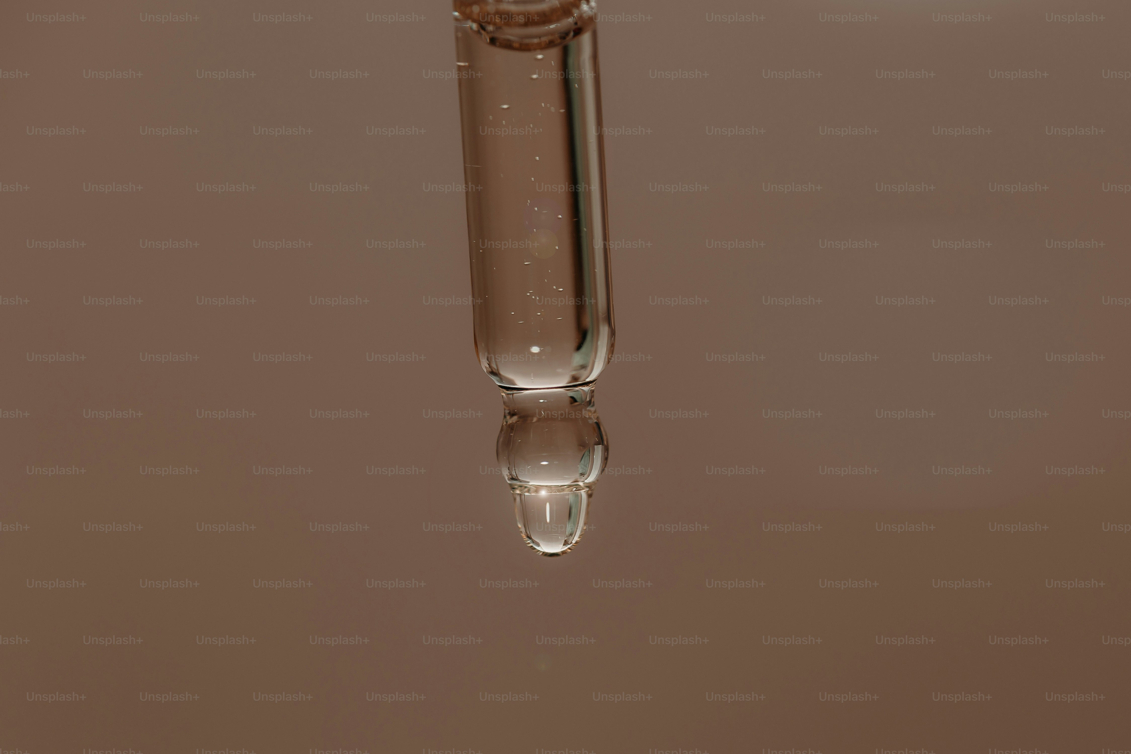 Un gotero con una gota de líquido en suspensión.