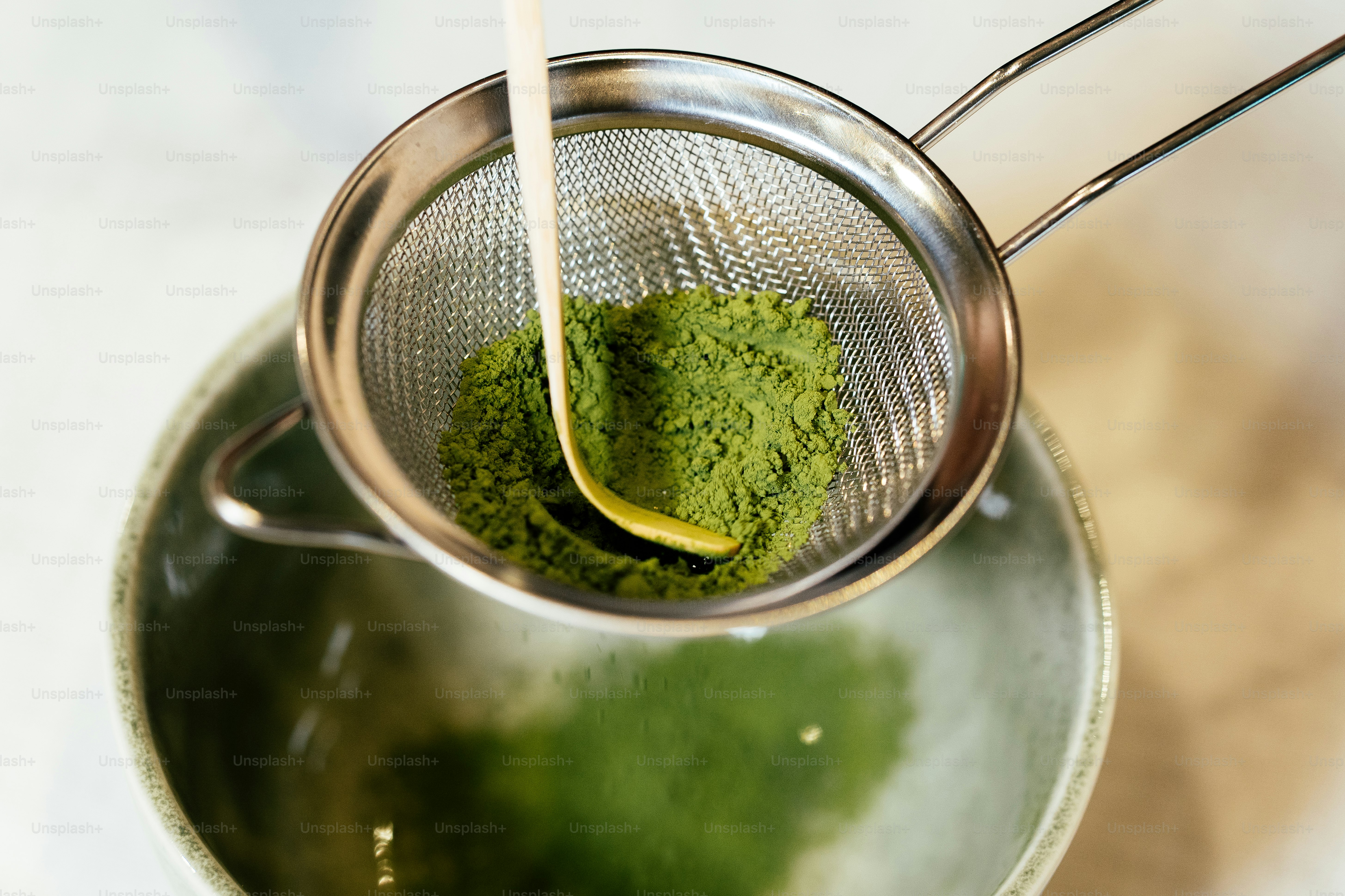 Menyaring bubuk matcha ke dalam mangkuk.