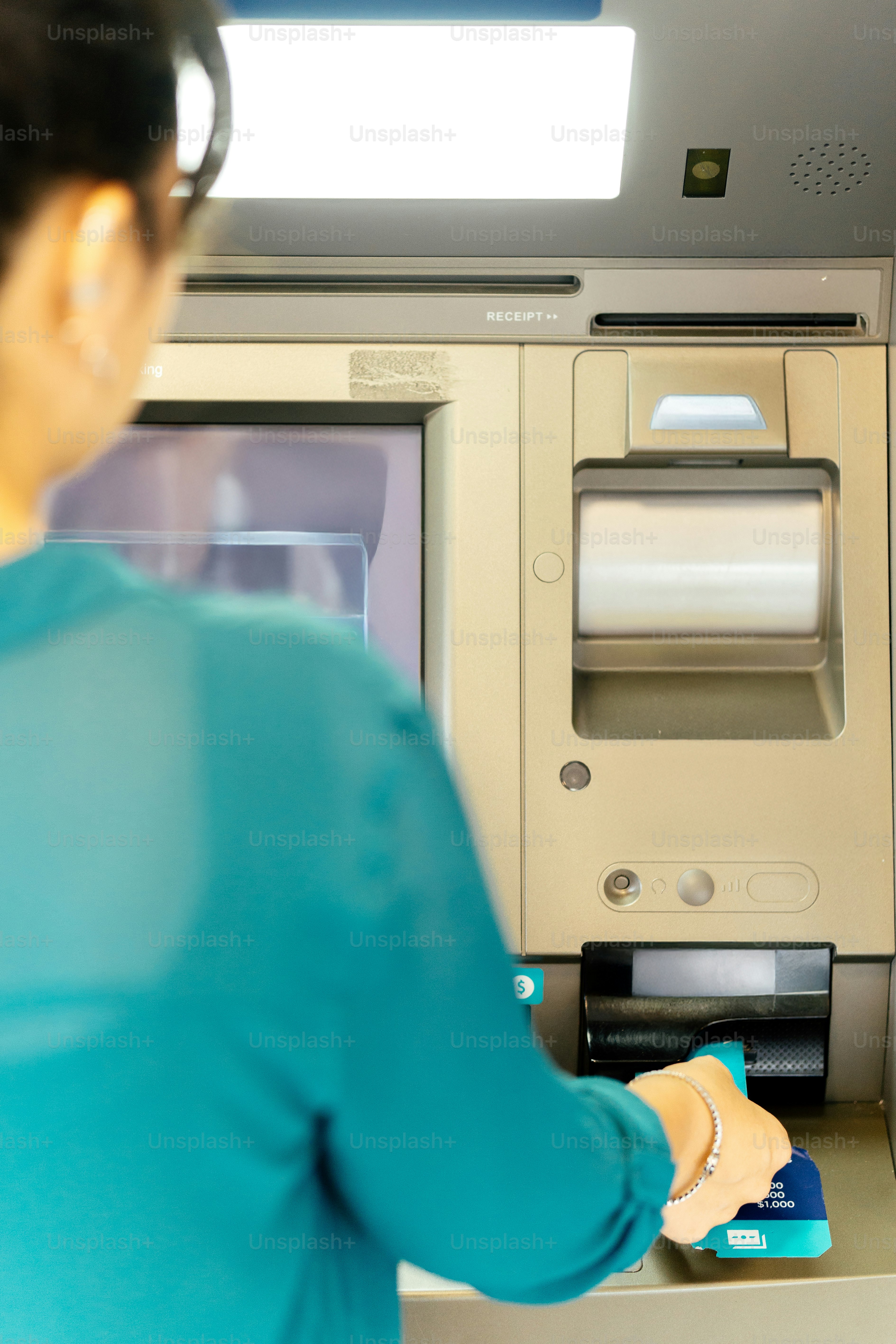 Femme utilisant un distributeur automatique de billets pour retirer de l’argent