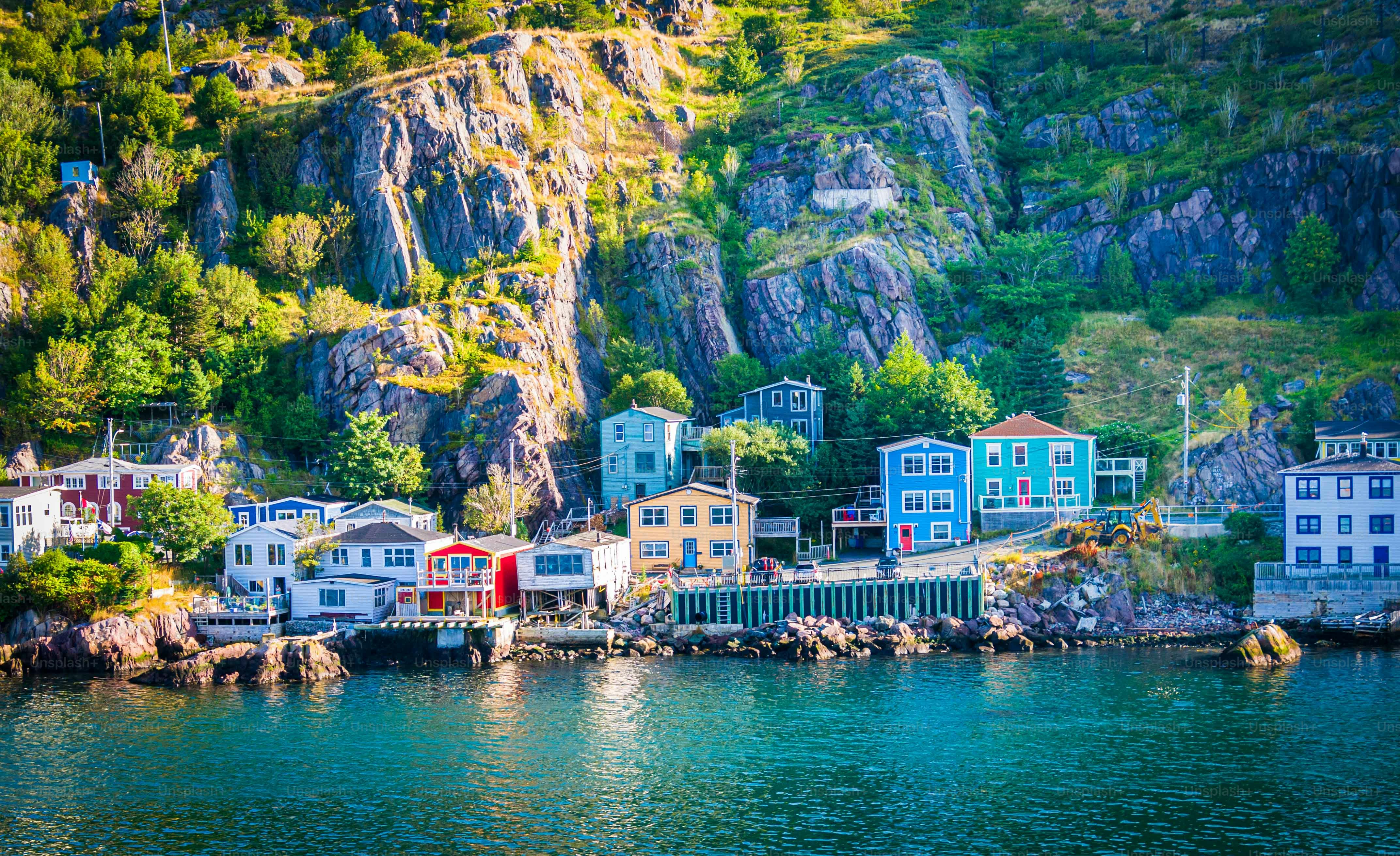 Morning light illuminates colorful homes on  the rocky hillside of The Narrows, an inlet entering St. John's Harbor in Newfoundland, Canada