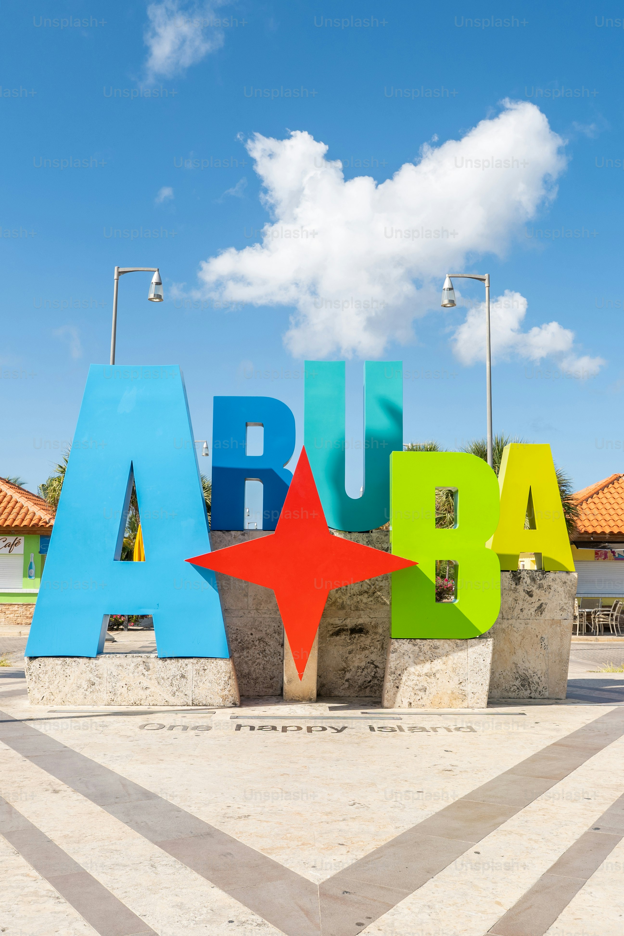 Panneau Aruba coloré avec ciel bleu. Destination de voyage populaire pour les touristes. Monument lumineux dans un cadre insulaire ensoleillé.