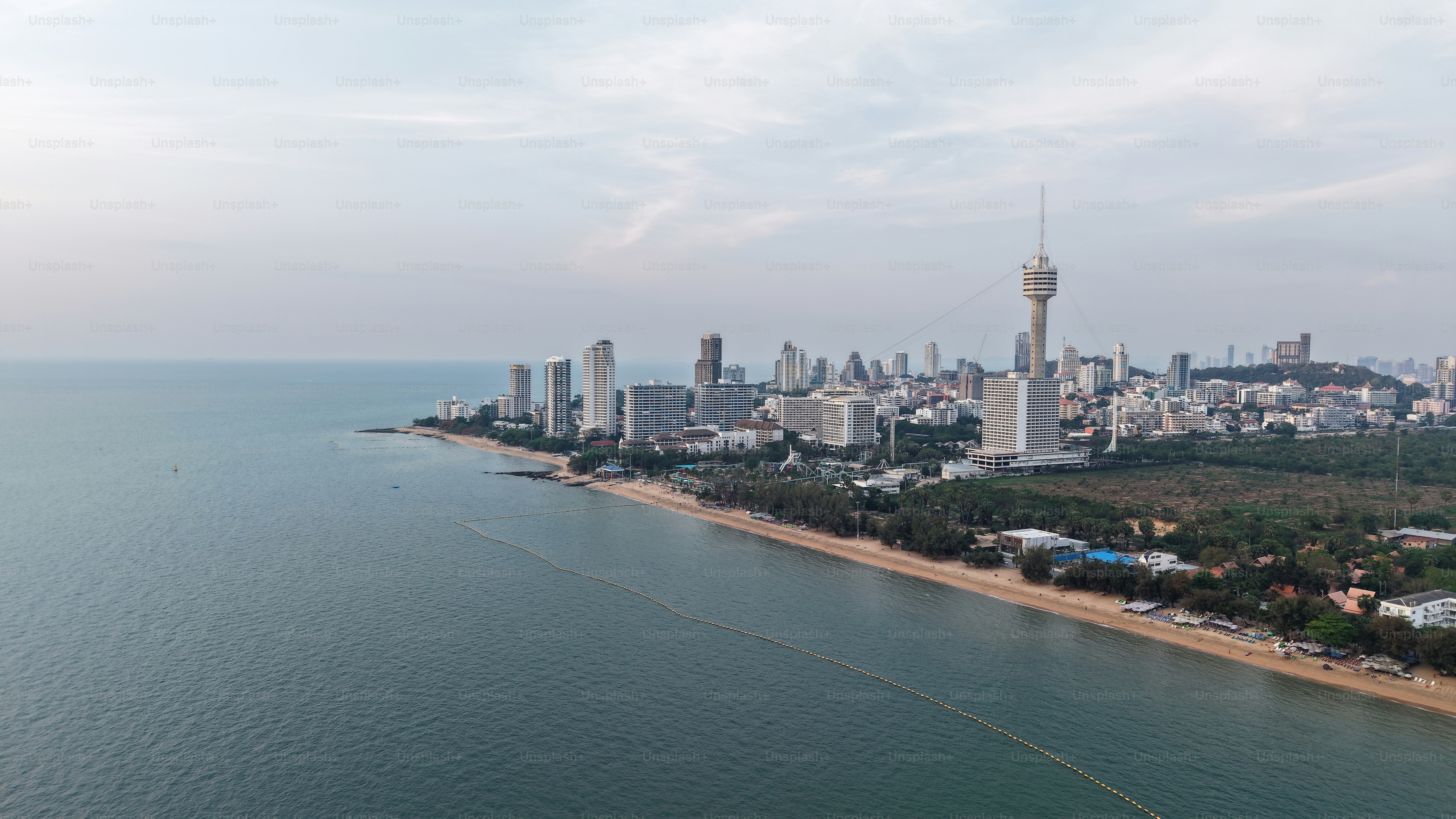 Moderne Gebäude, die sich entlang der Küste von Pattaya erheben, schaffen bei näherer Dämmerung ein atemberaubendes Stadtbild vor der Kulisse des Ozeans und verbinden städtische Entwicklung mit natürlicher Schönheit