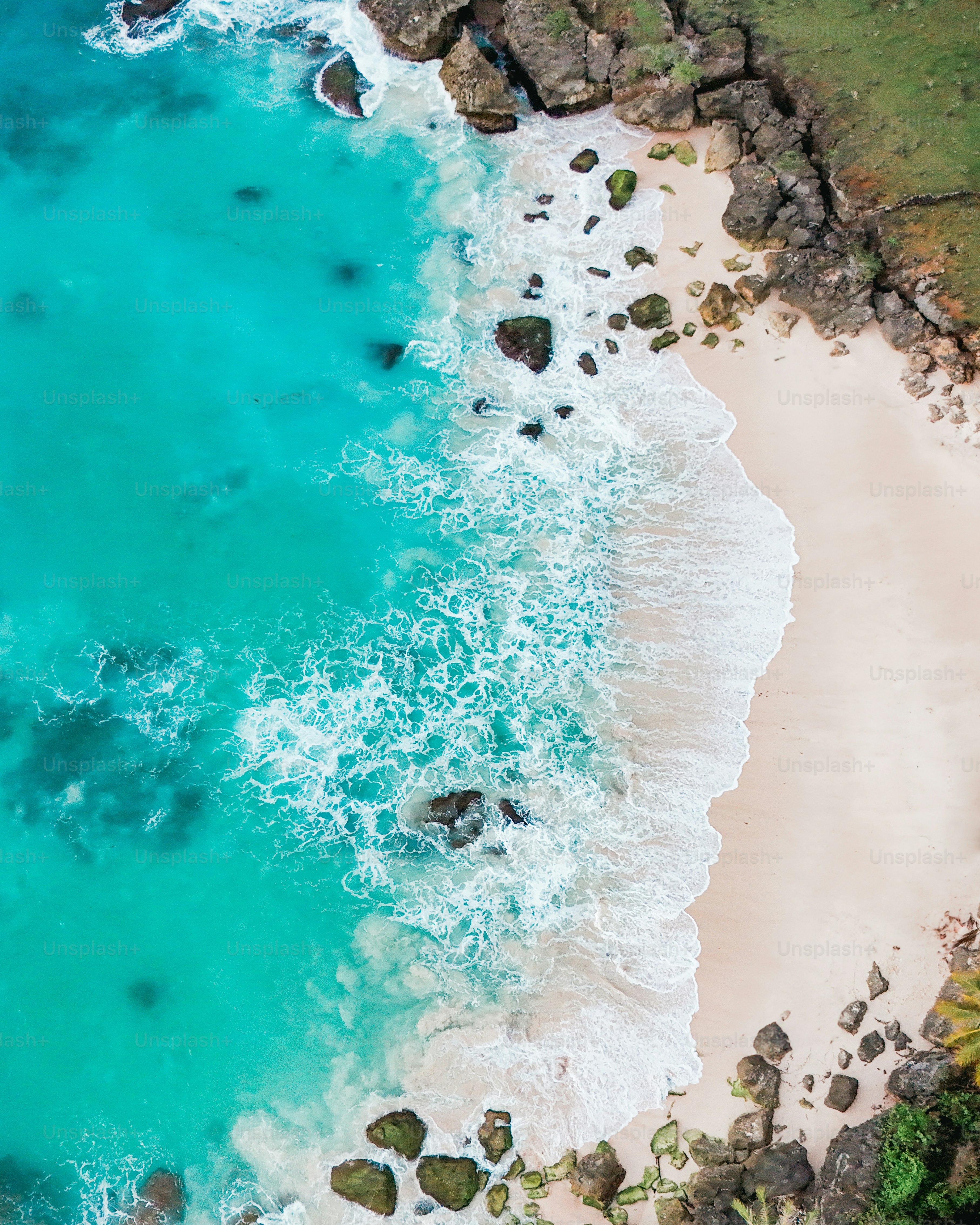 Pemandangan pantai udara dari air biru kehijauan yang jernih dan pantai berpasir putih yang belum tersentuh