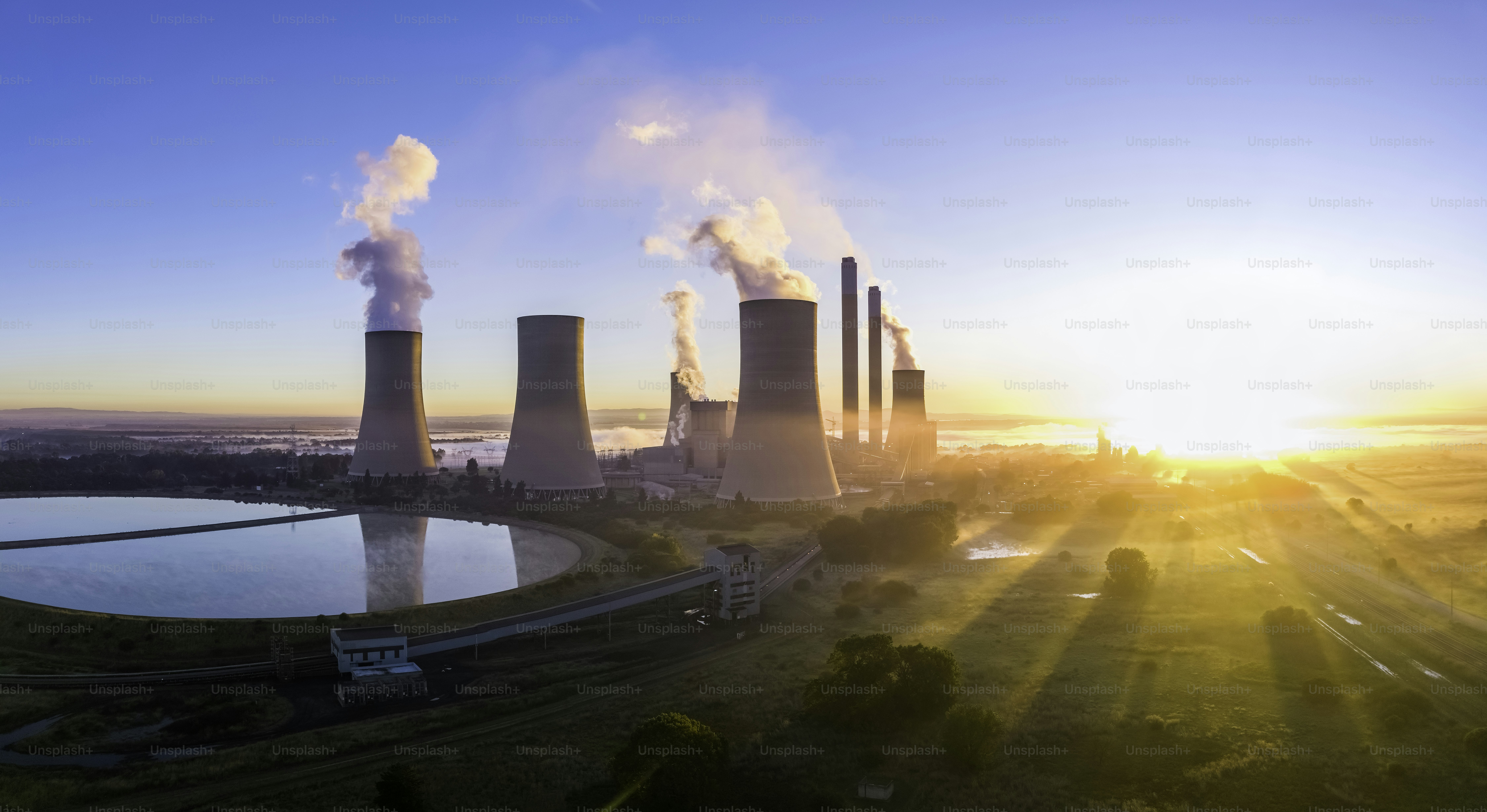 Lethabo Power station seen at  sunrise with the smog and mist over the countryside and steam rising from the cooling towers.