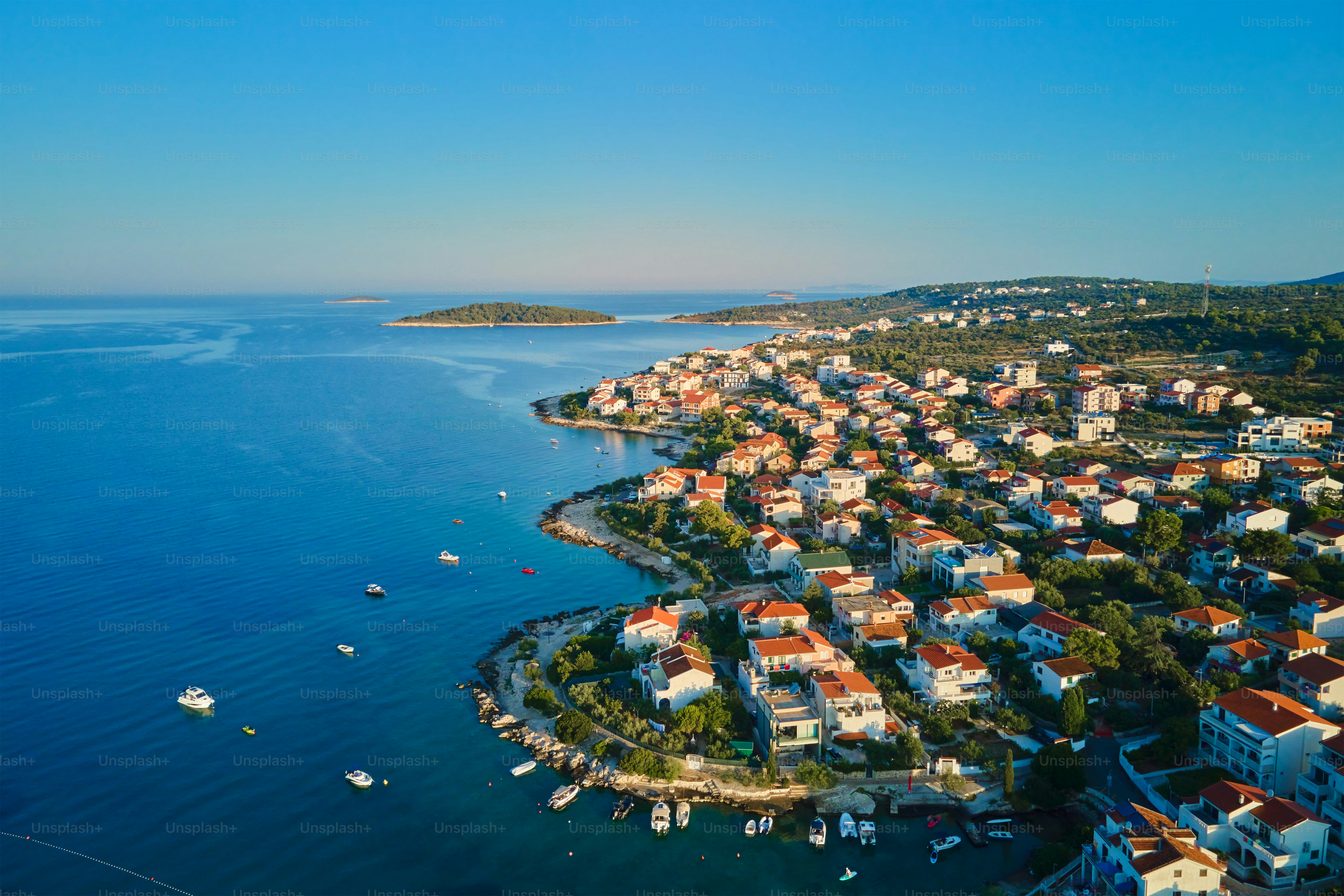 Aerial view of Adriatic sea coastline with coastal village and boats along shoreline. Panorama of tourist town Rogoznica in Croatia on Adriatic Sea. Summer travel concept