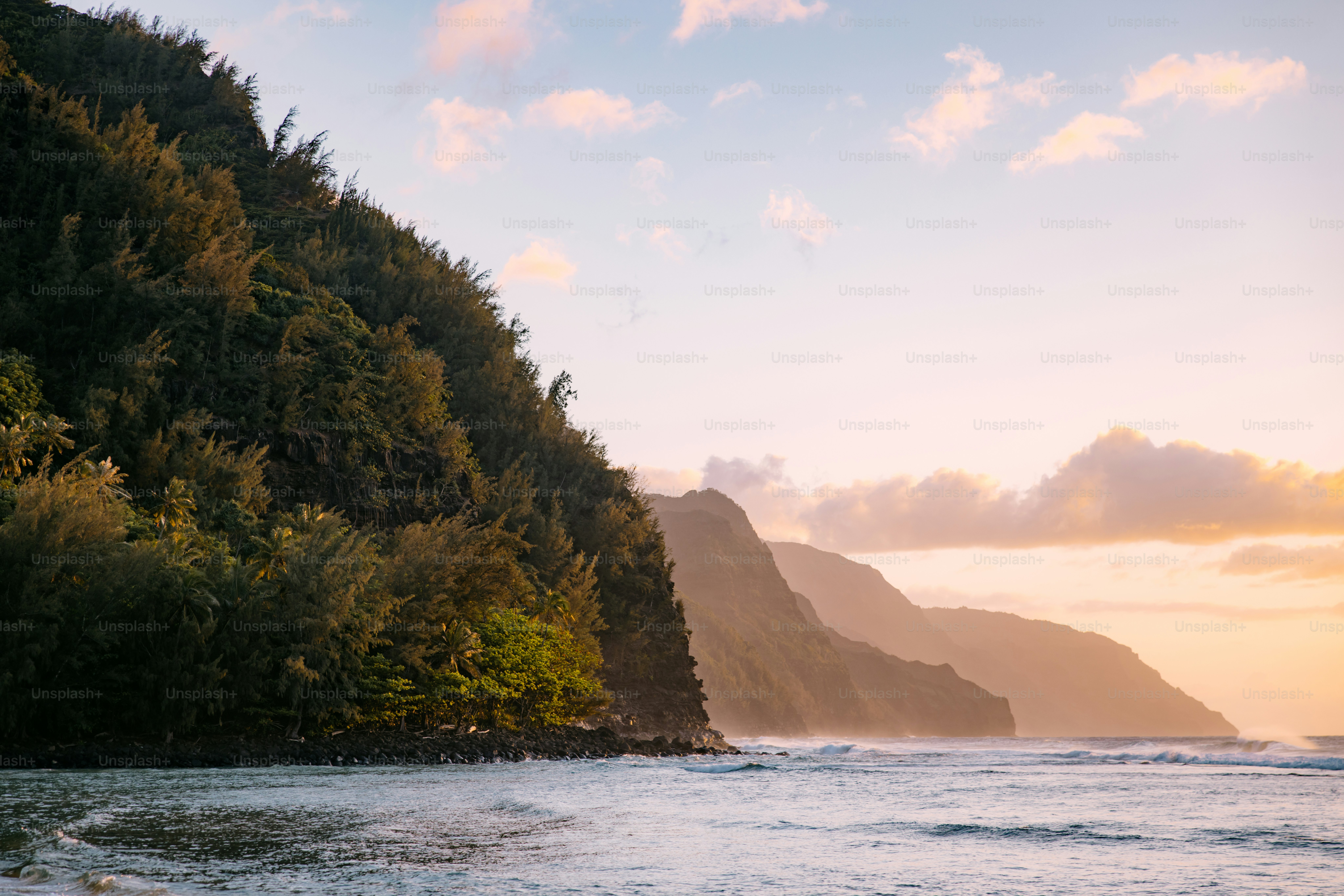 Pemandangan geologi yang indah di mana Samudra Pasifik bertemu dengan Pantai Nā Pali di Kauai, di kepulauan Hawaii.  Pengalaman alam ajaib untuk dijelajahi.