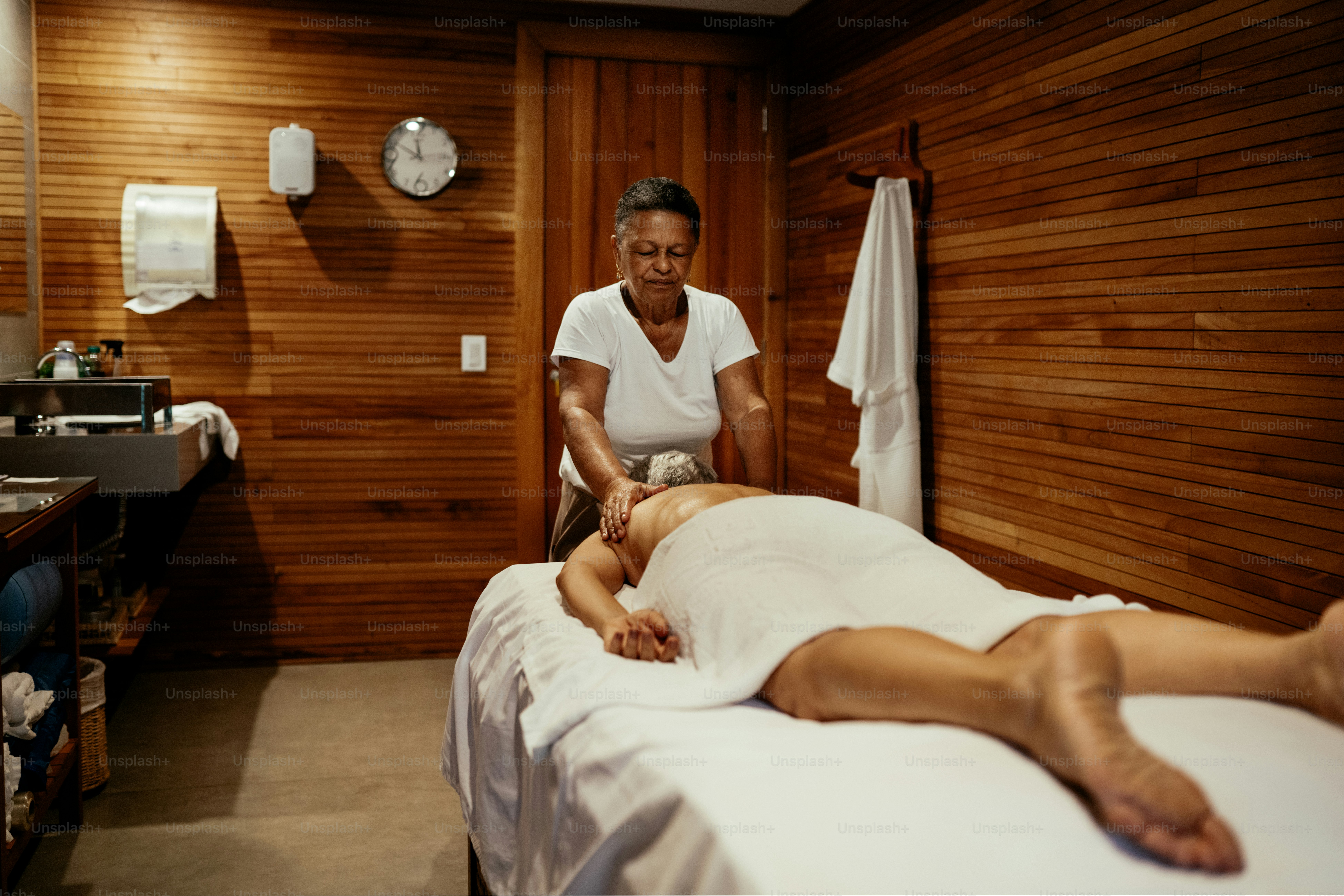 Tukang pijat memberikan pijatan kepada wanita dewasa di spa mewah