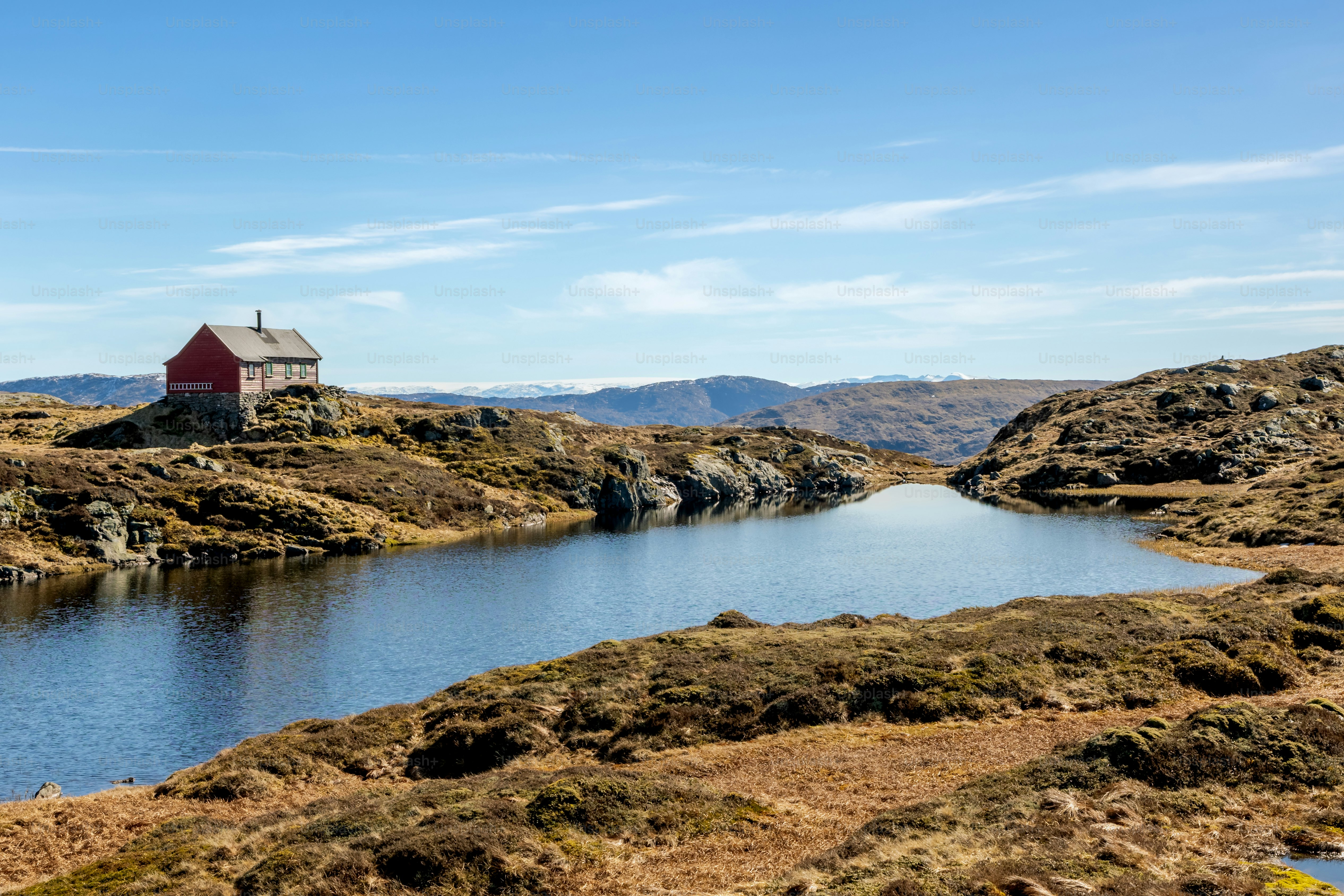 Paesaggio montano con cabina rossa e lago vicino a Bergen in primavera