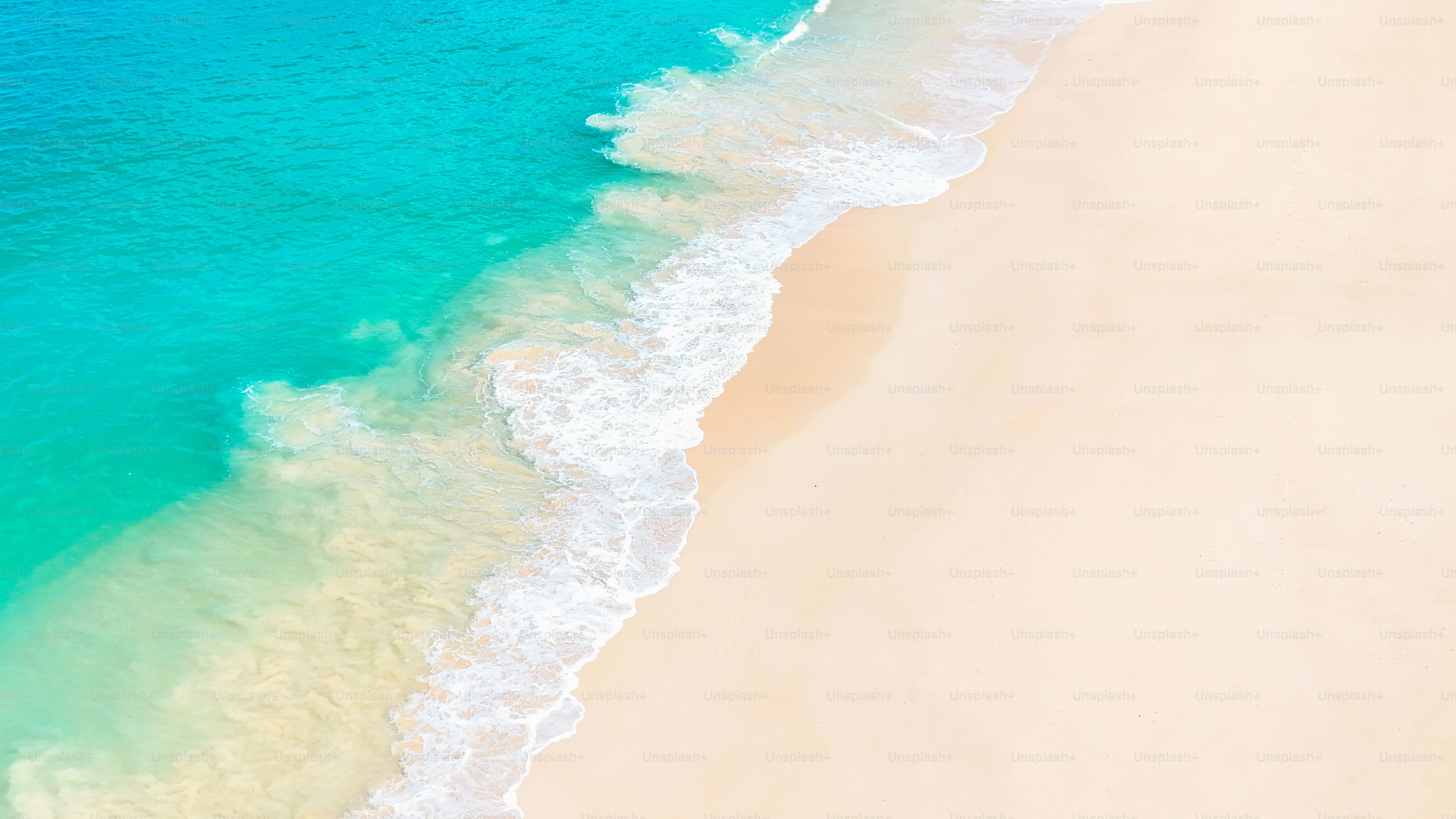 Tranquil ocean waves rolling onto pristine white sand on a dreamy tropical beach.