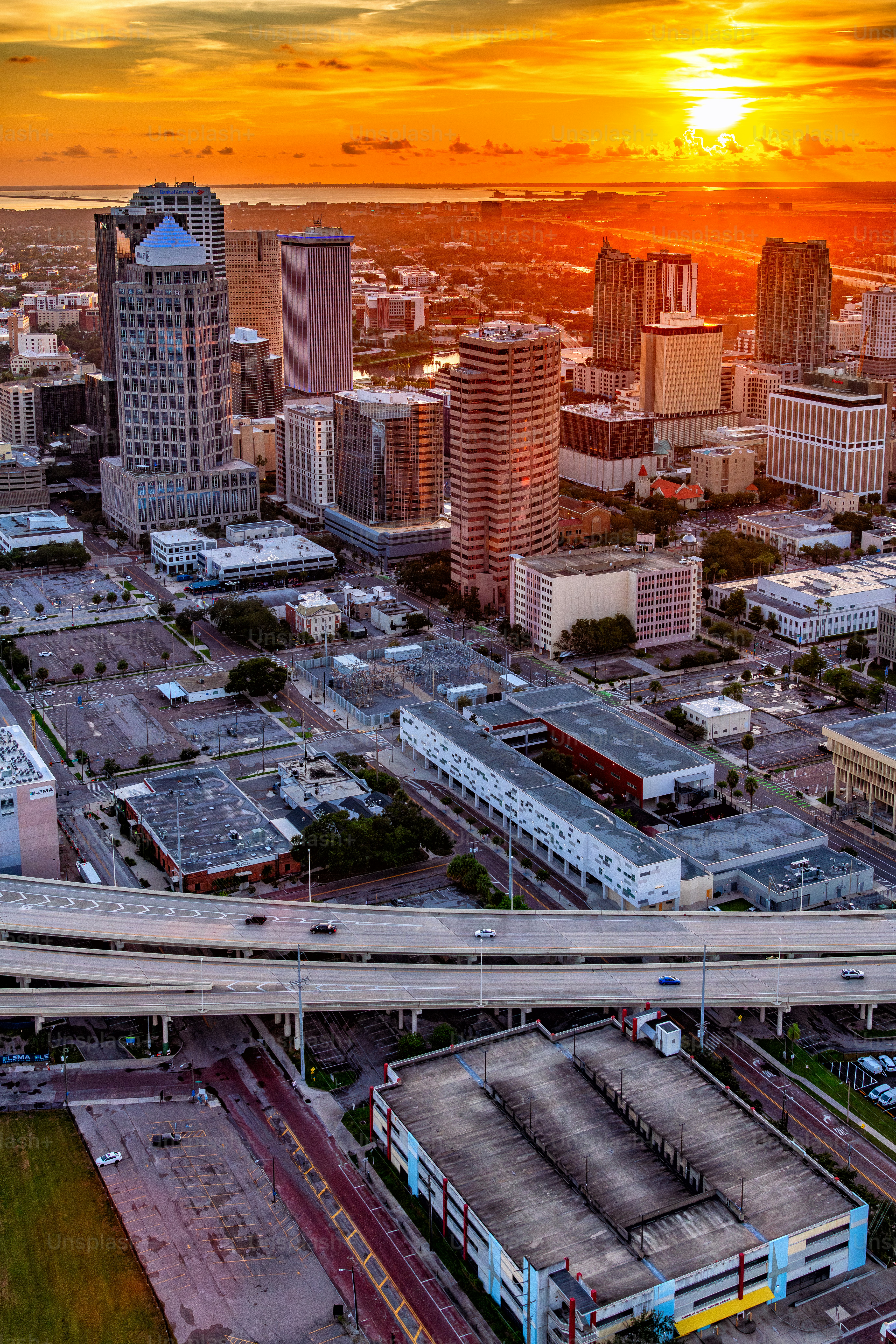 Vista aérea do centro de Tampa, Flórida e dos bairros vizinhos filmada de helicóptero ao pôr do sol de uma altitude de cerca de 800 pés.