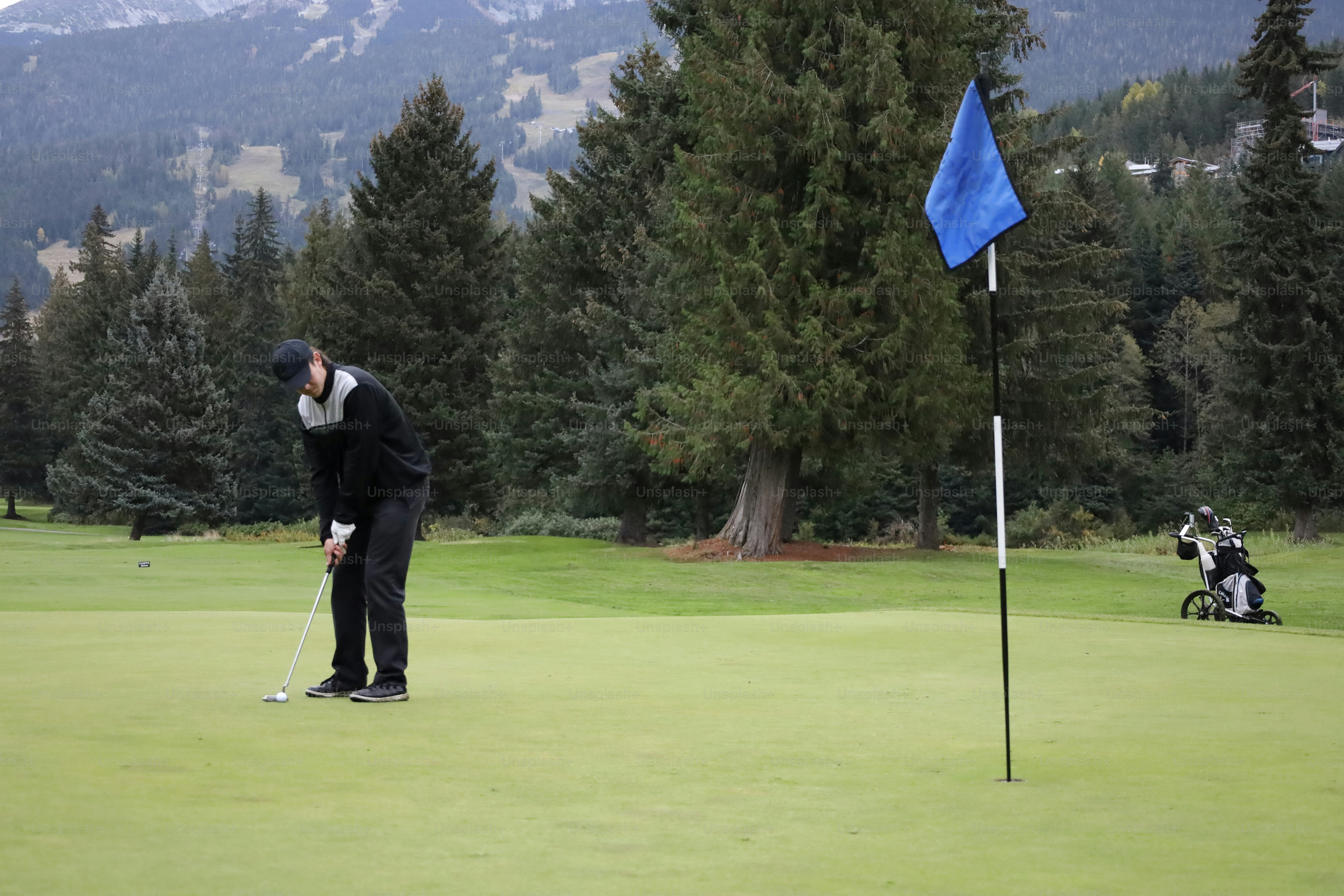 Man golfs on golf course in mountains, Whistler, B.C.