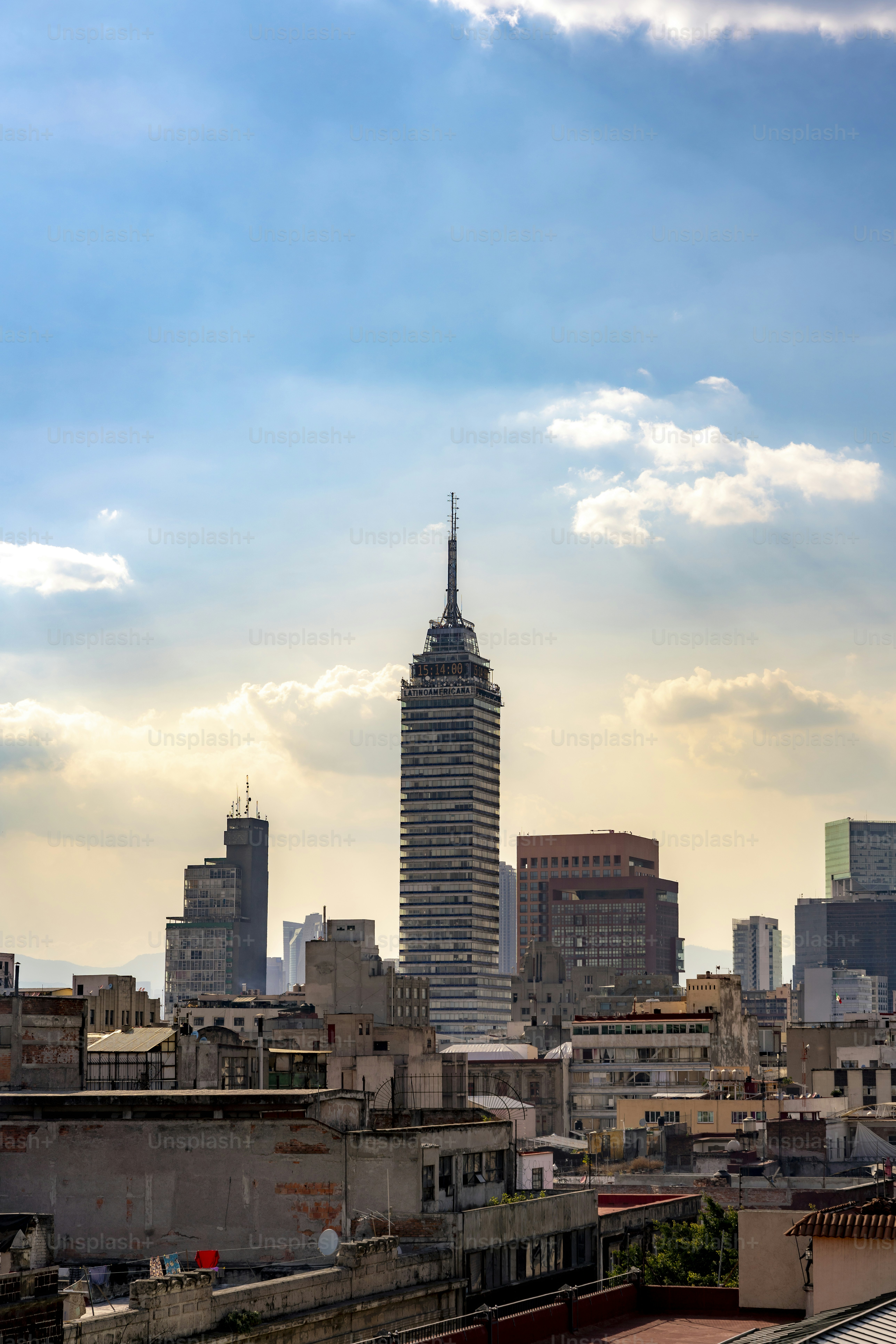 Die Skyline von Mexiko-Stadt mit dem Torre Latinoamericana und modernen Wolkenkratzern, eingefangen während des Sonnenuntergangs mit dramatischen Wolken und goldenem Licht.