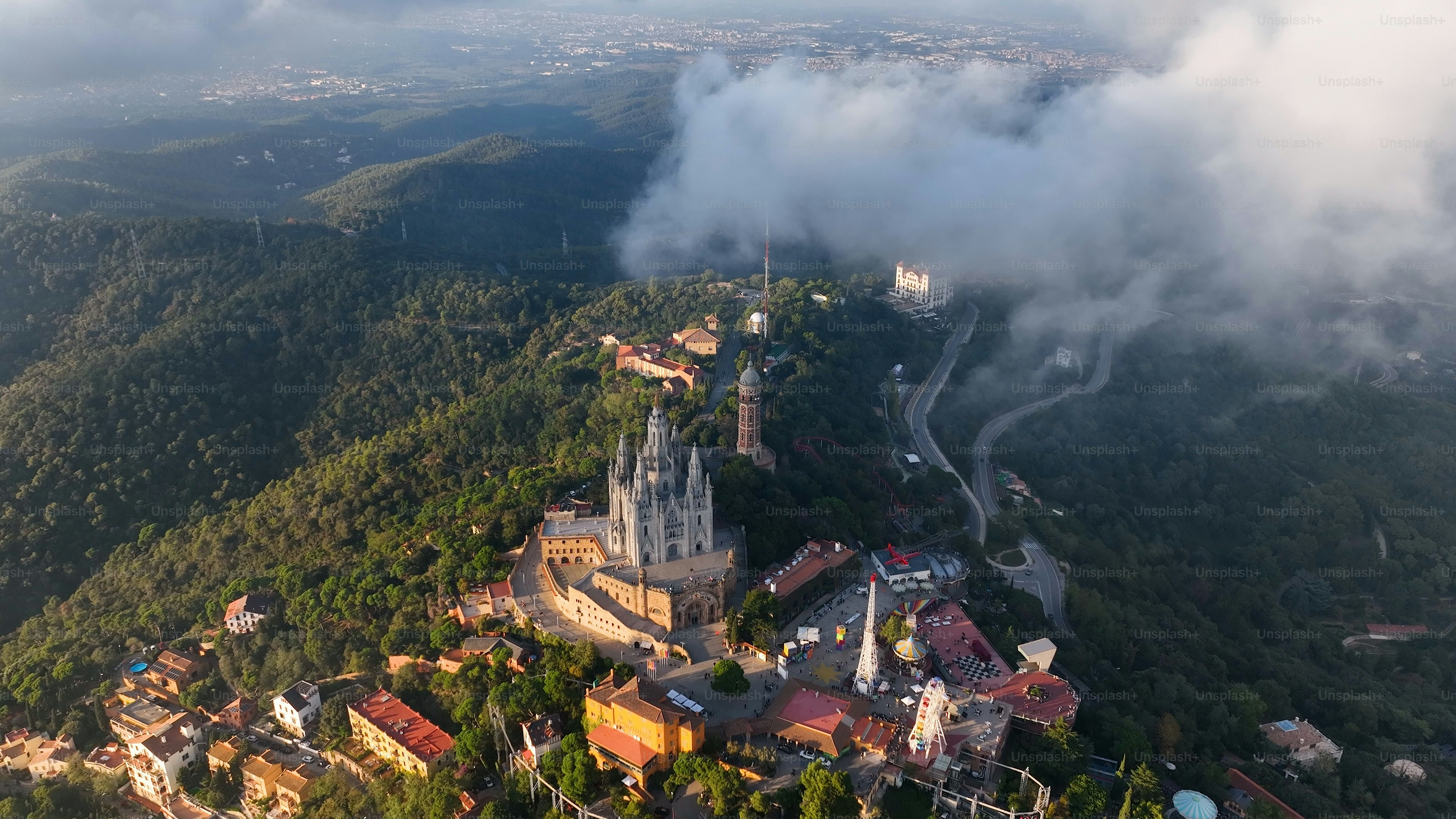 Barcelona, helicóptero aéreo do zangão Barcelona Tibidabo acima das nuvens e da névoa, templo de Sagrat Cor, Catalunha, Espanha