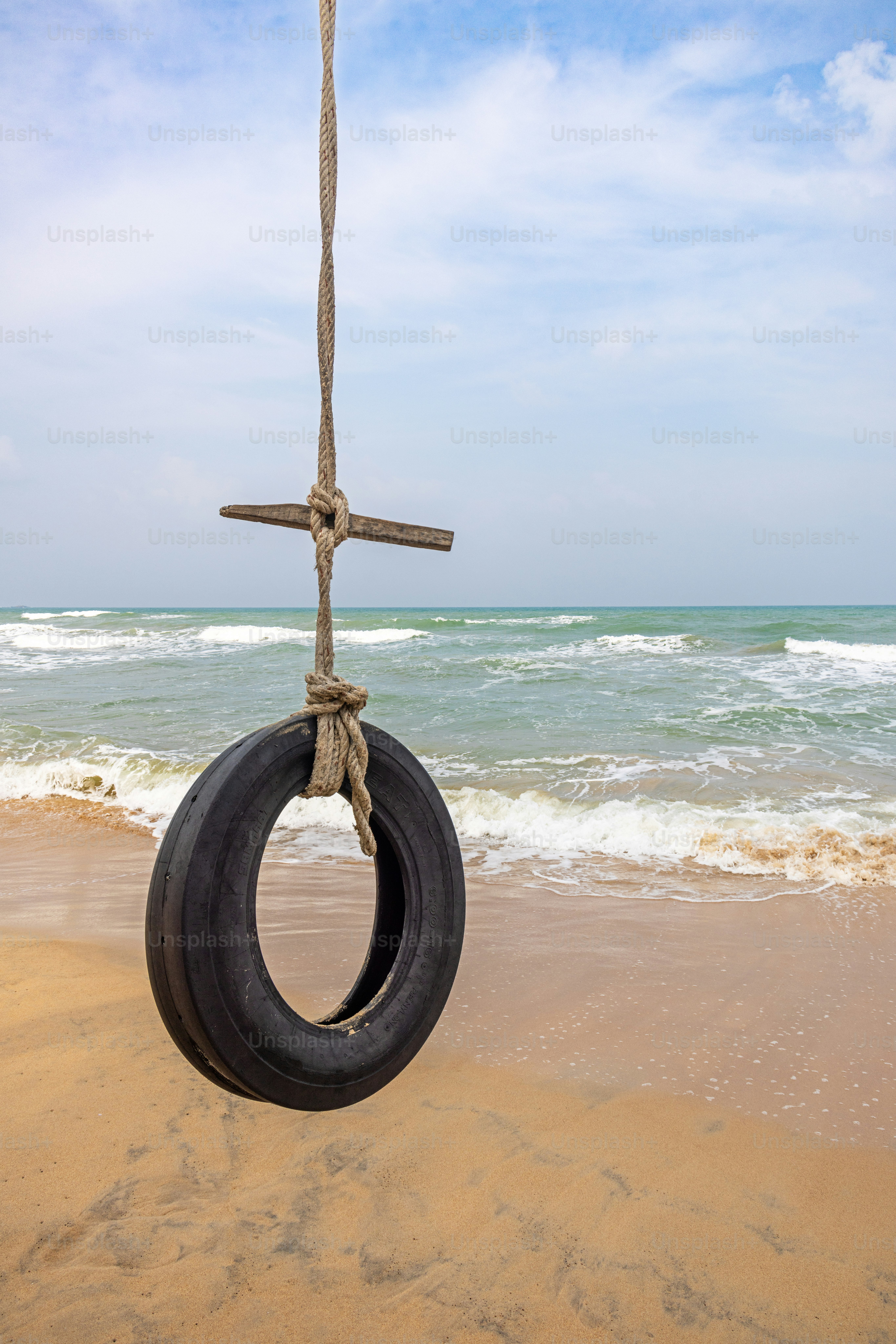 Old tire hanging from a coconut palm tree close to the Indian Ocean at the beach north of Trincomalee in the Easter Province in Sri Lanka