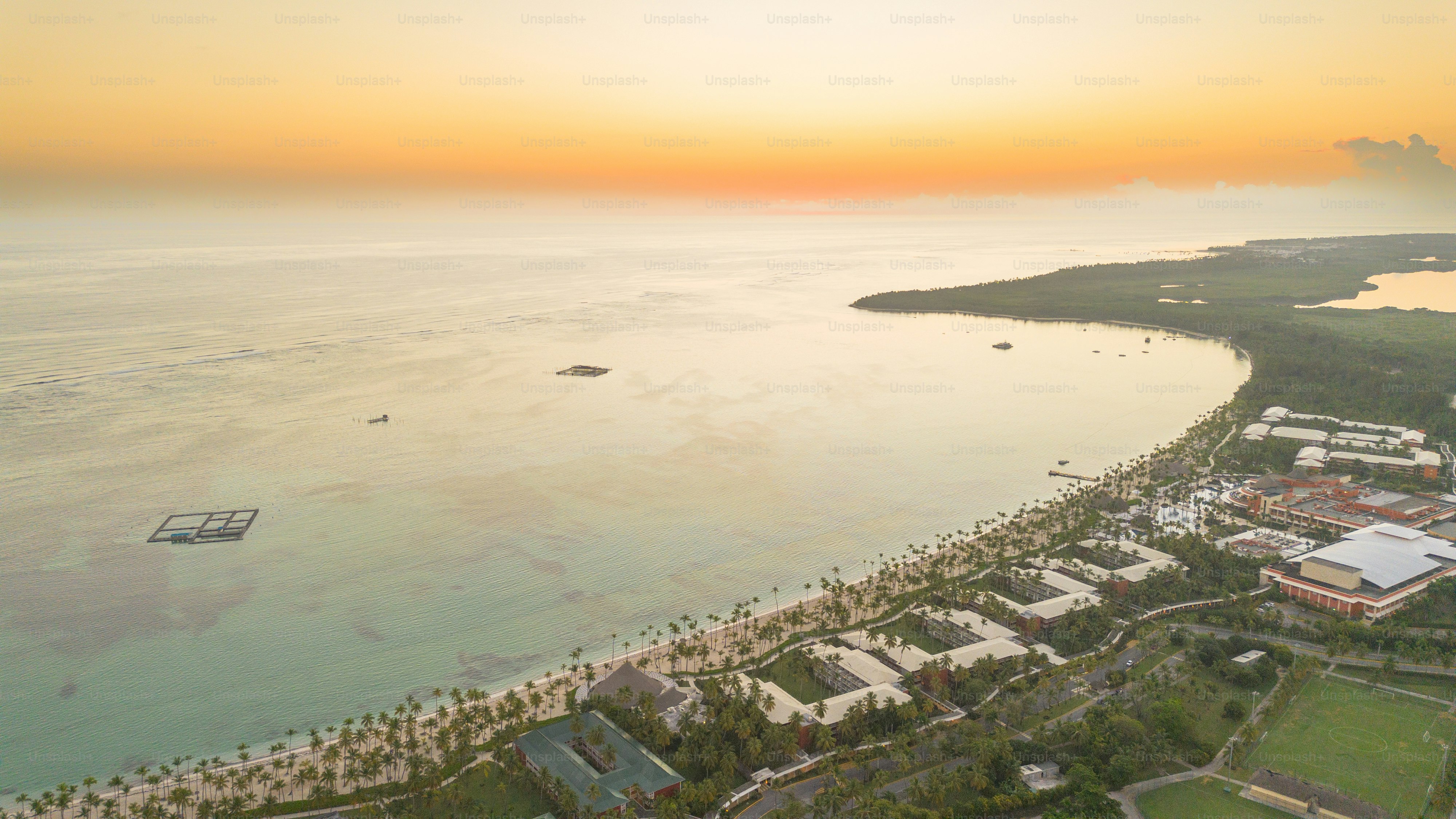 Guest enjoying coastal wellness resorts at sunrise beside a calm ocean shoreline