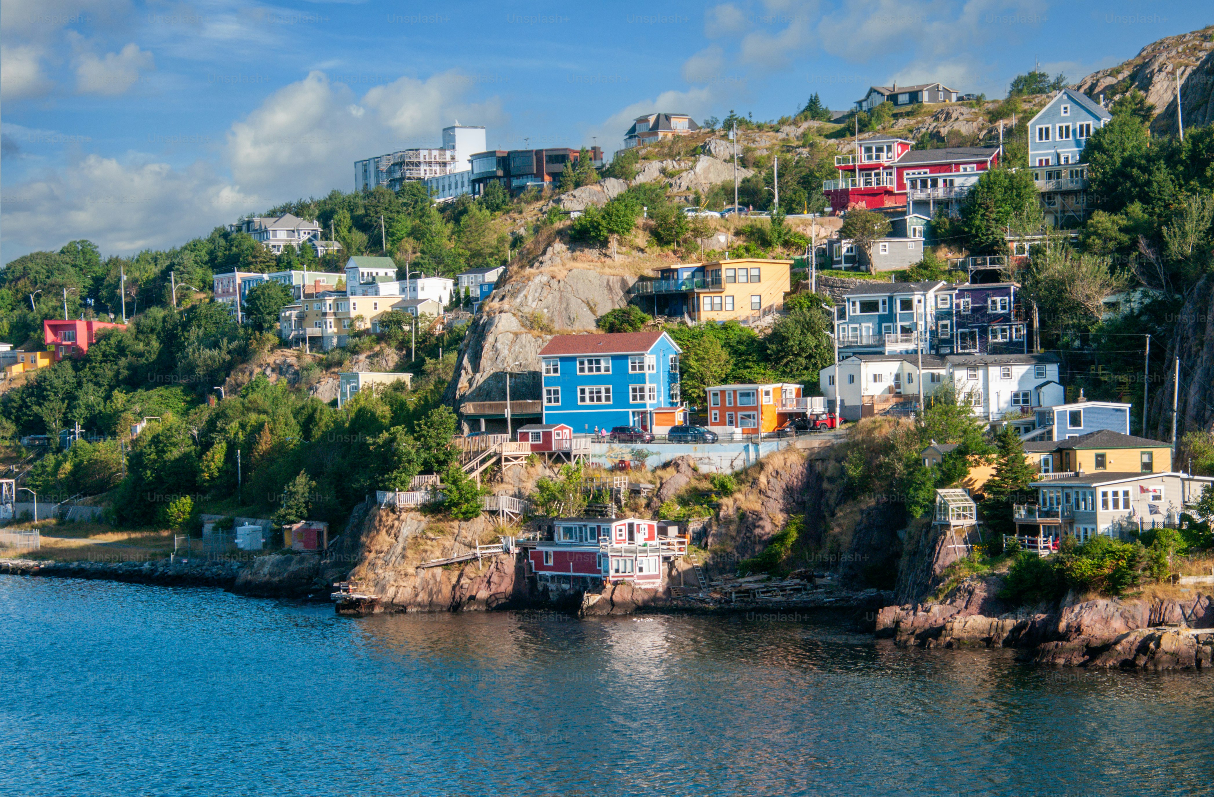 Morning light illuminates colorful homes on  the rocky hillside of The Narrows, an inlet entering St. John's Harbor in Newfoundland, Canada