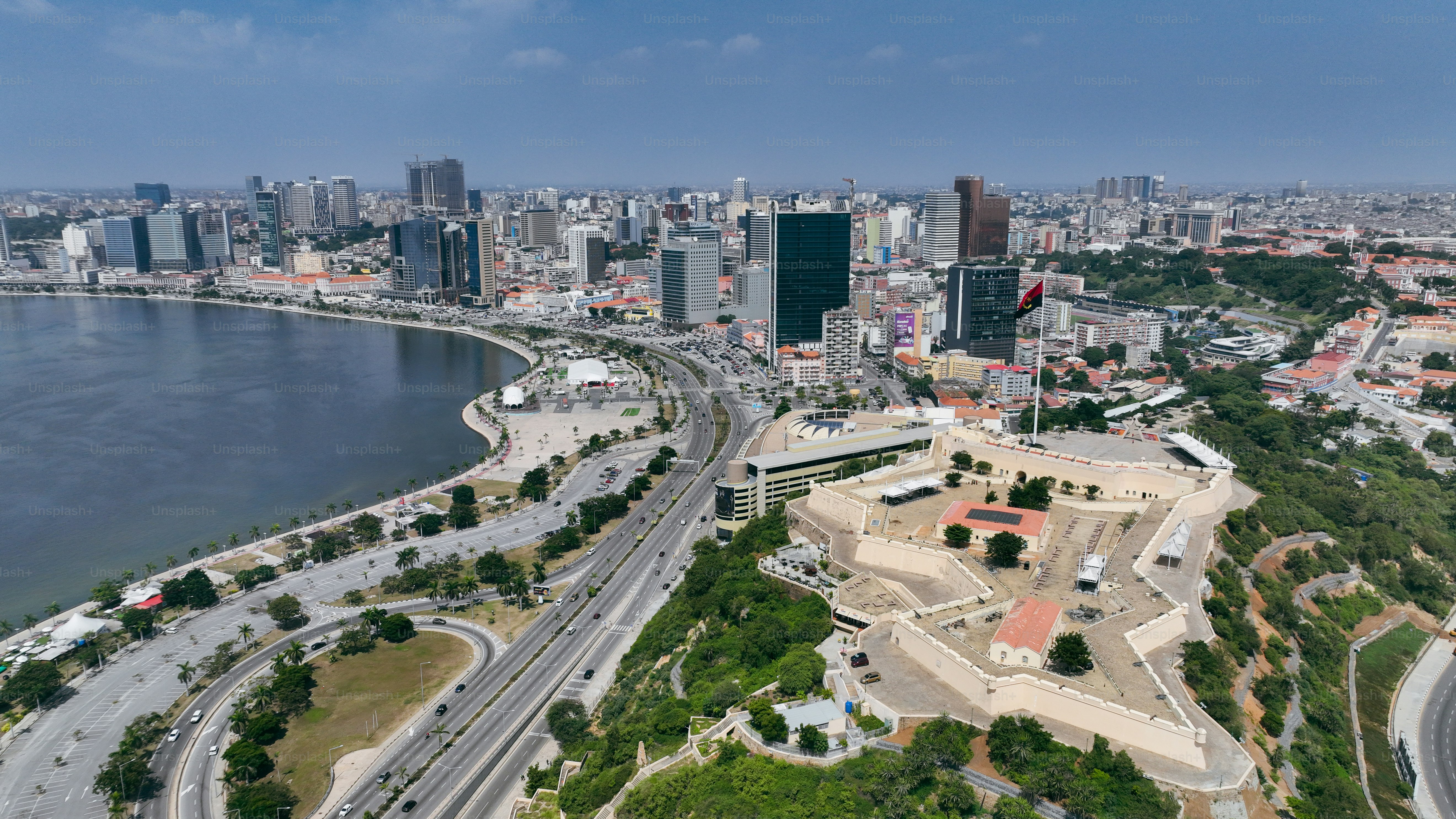A sweeping view of Luanda's skyline with modern buildings, coastal areas, and vibrant city life along the waterfront.