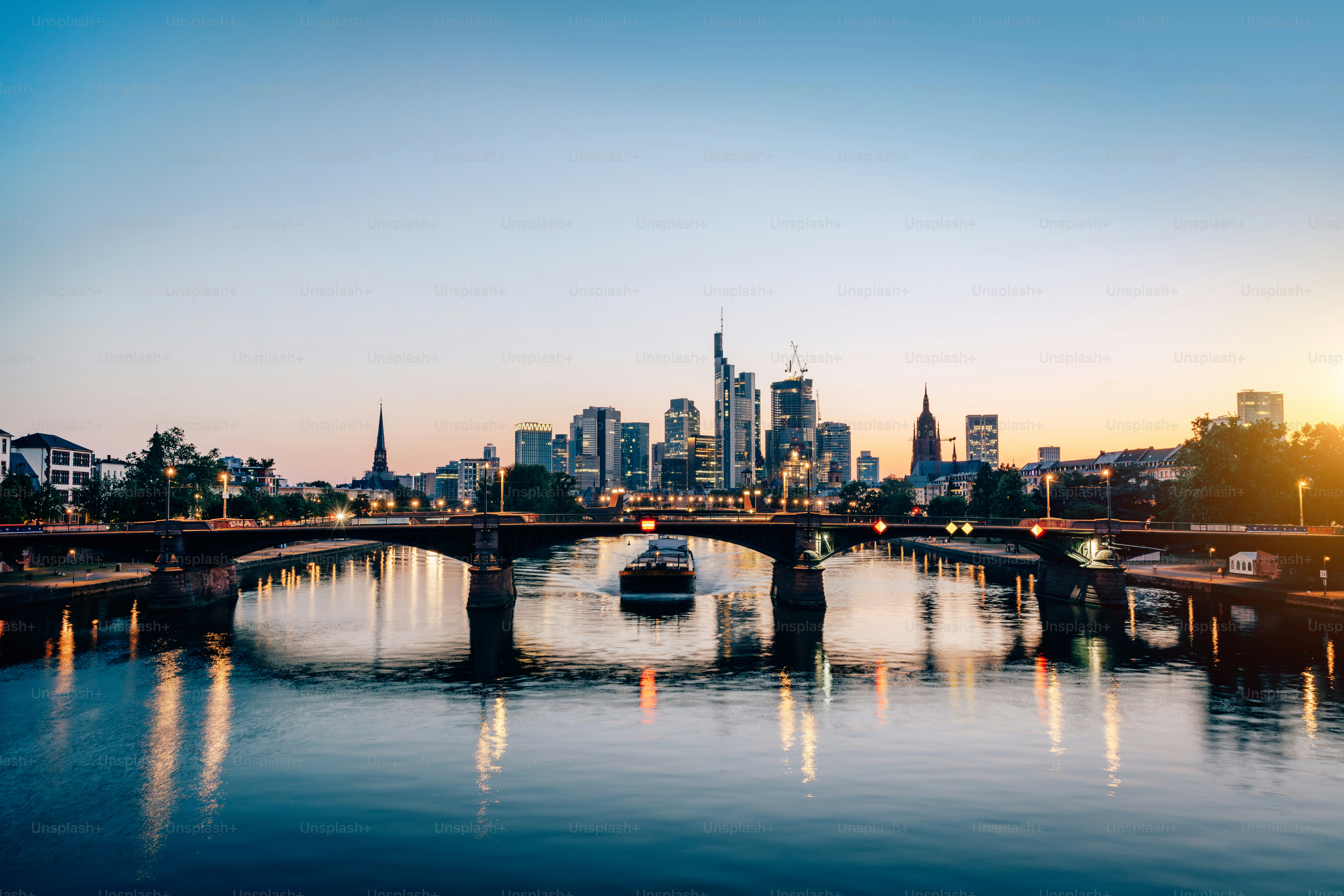 Frankfurt am Main skyline e ponte Ignatz Bubis Bridge durante a hora azul da noite com reflexos de espelho no rio, Alemanha