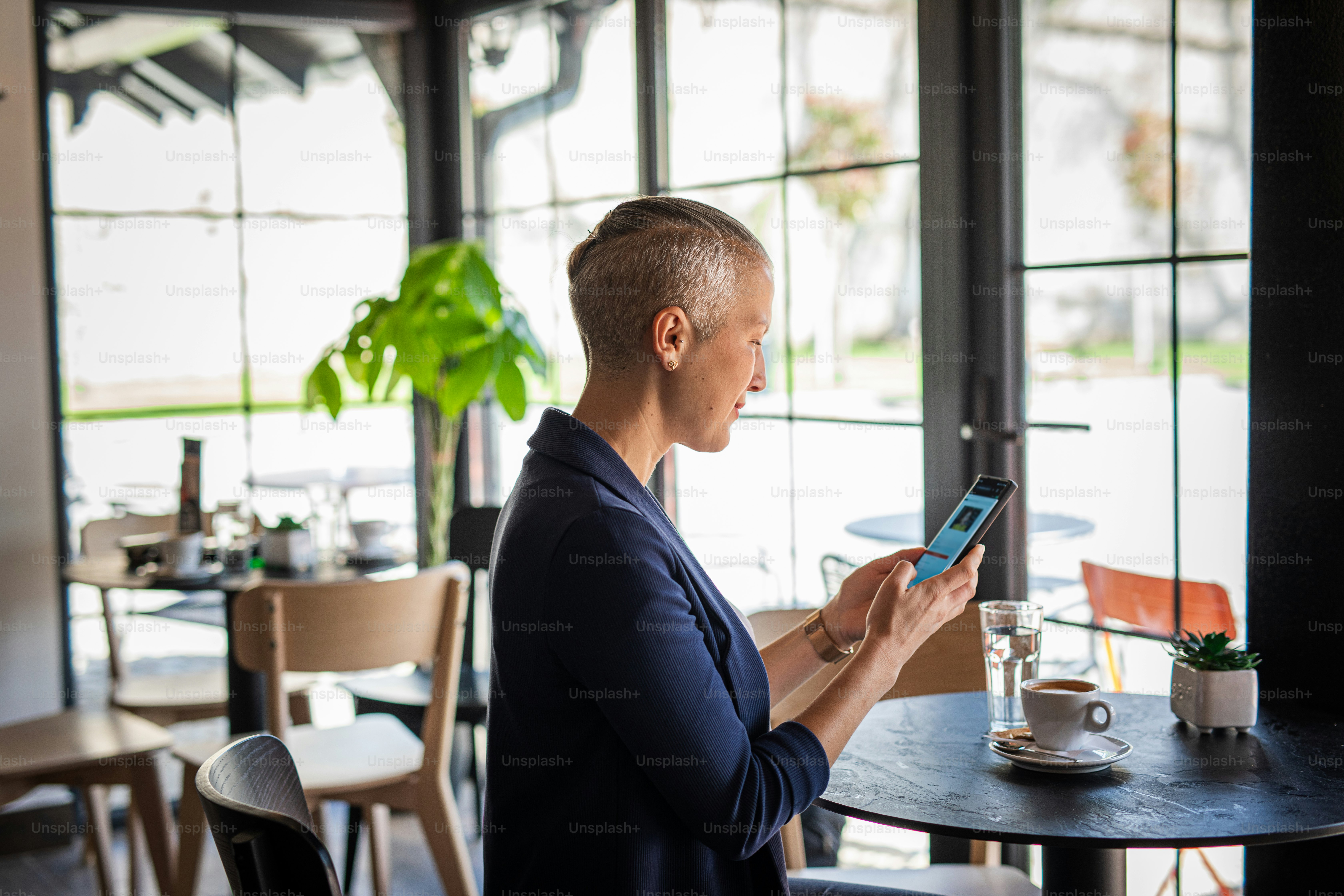 Beautiful business woman sitting in a coffee shop using phone photo ...