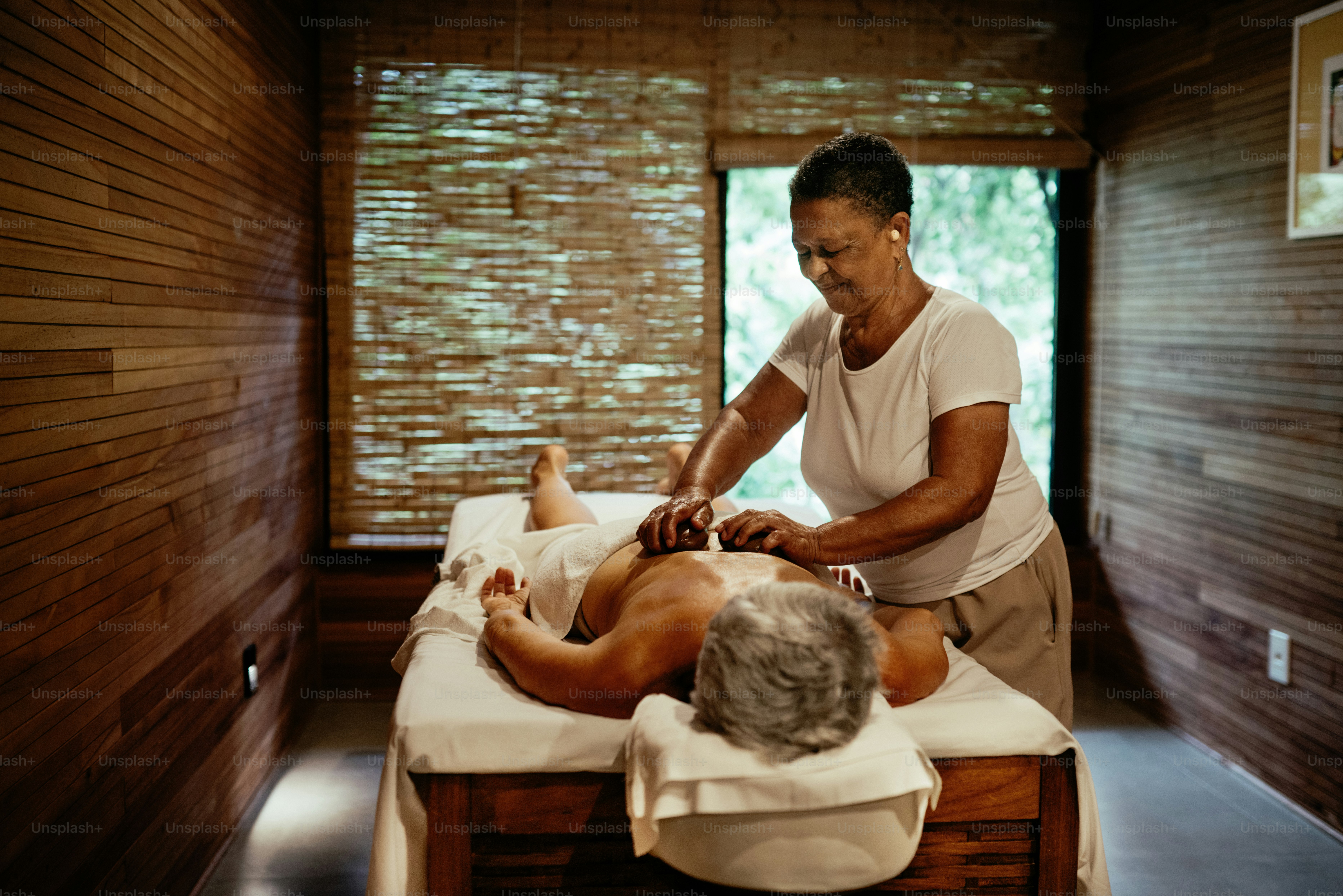 Tukang pijat memberikan pijatan kepada wanita dewasa di spa mewah