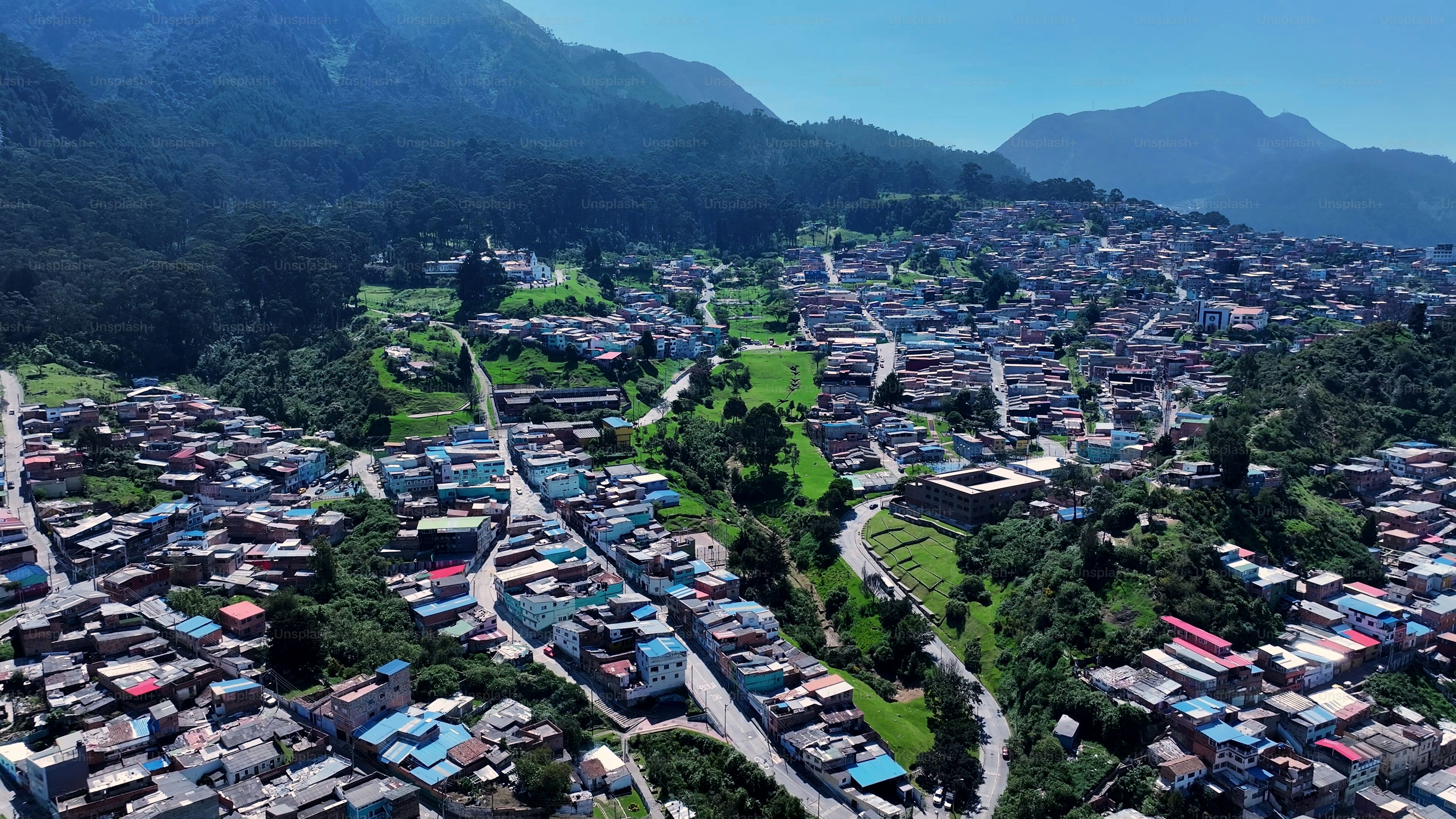 Vista aerea di una città incastonata in una rigogliosa valle montana