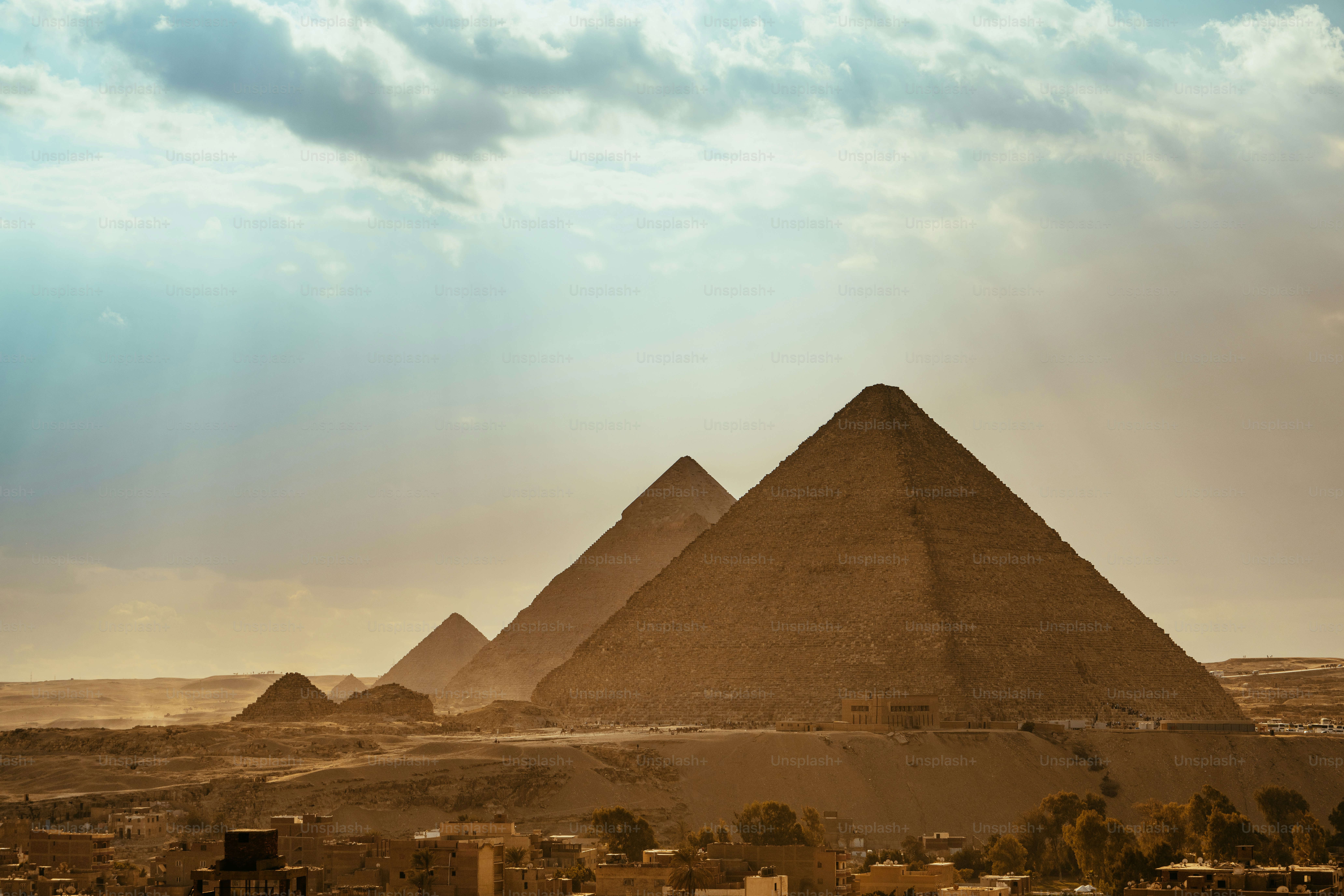 The majestic pyramids of Giza stand under a dramatic sky, capturing the essence of ancient Egyptian architectural brilliance