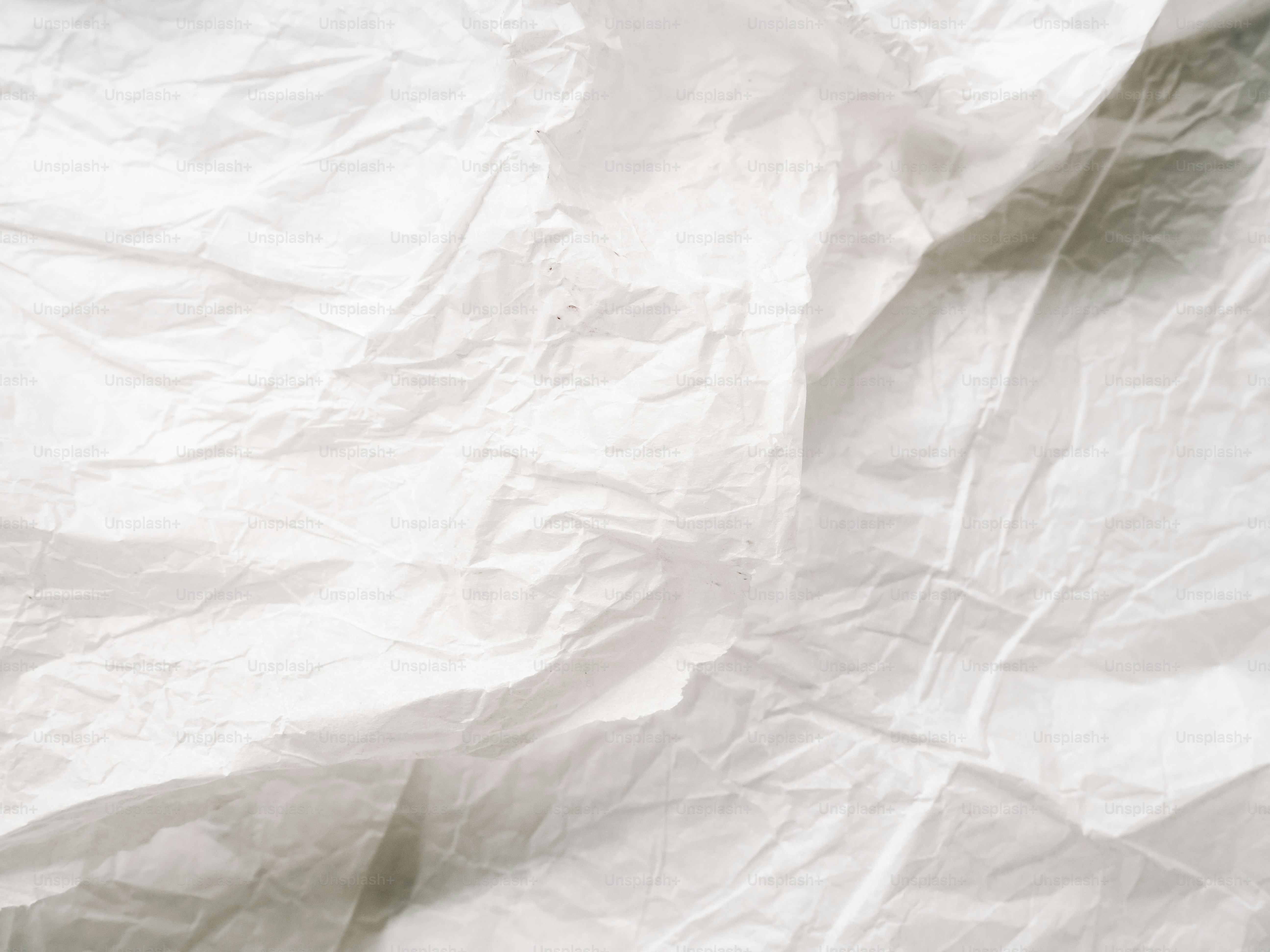 Fondo de papel blanco arrugado con sombras.