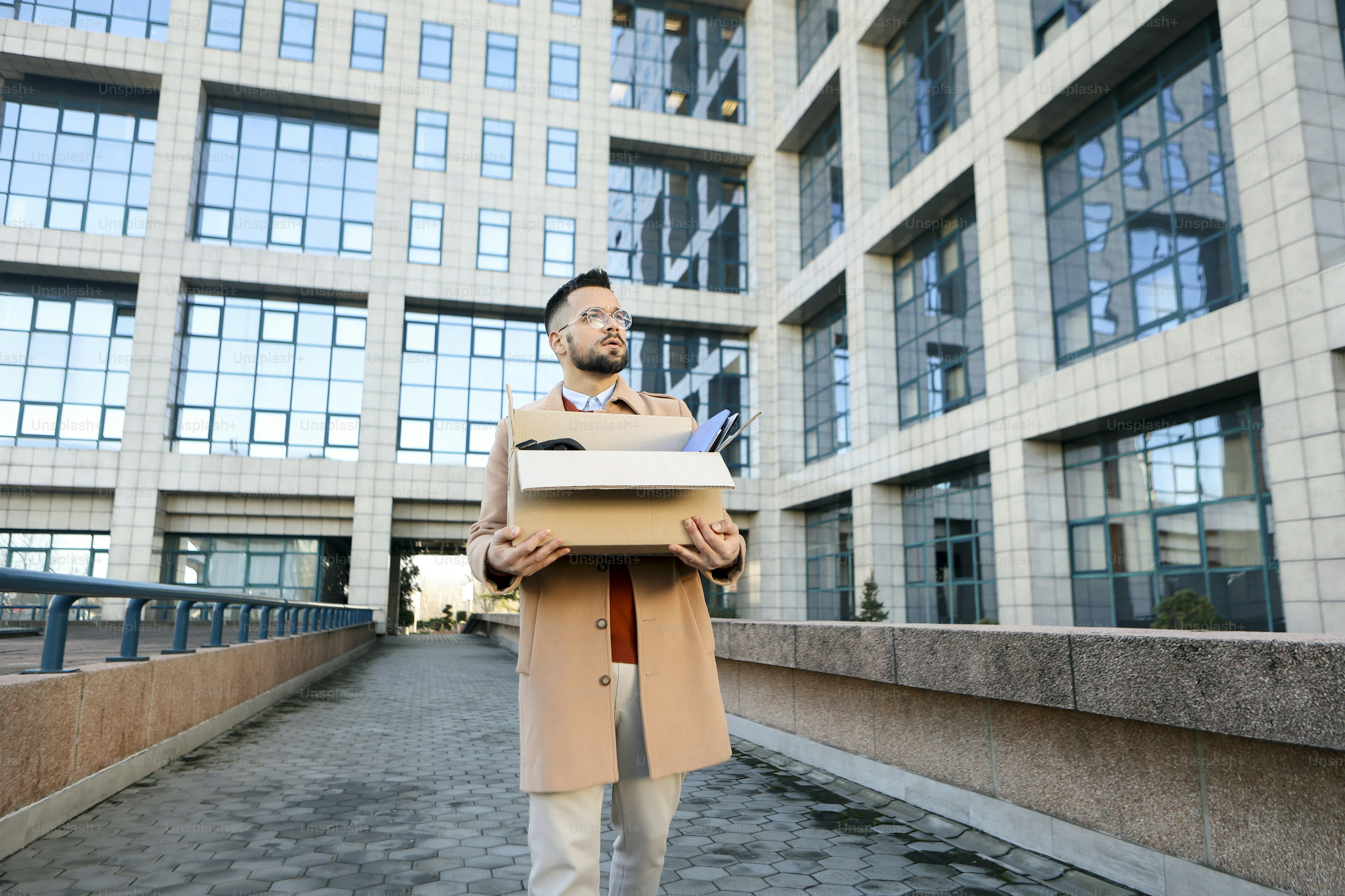 Mid adult man walking in a city street after being fired. About 30 years old, Caucasian male