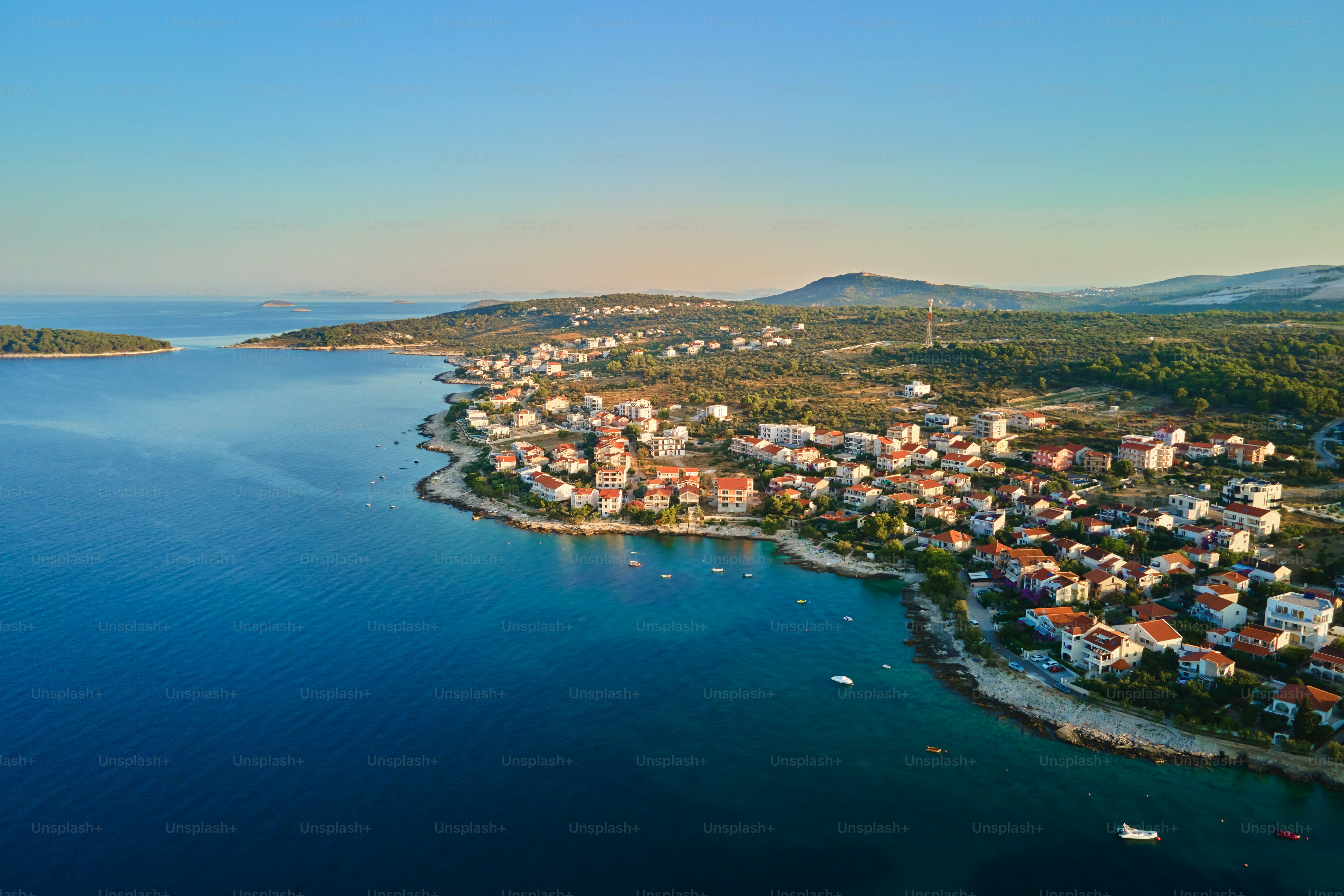Pemandangan udara garis pantai laut Adriatik dengan desa pesisir dan perahu di sepanjang garis pantai. Panorama kota wisata Rogoznica di Kroasia di Laut Adriatik. Konsep perjalanan musim panas