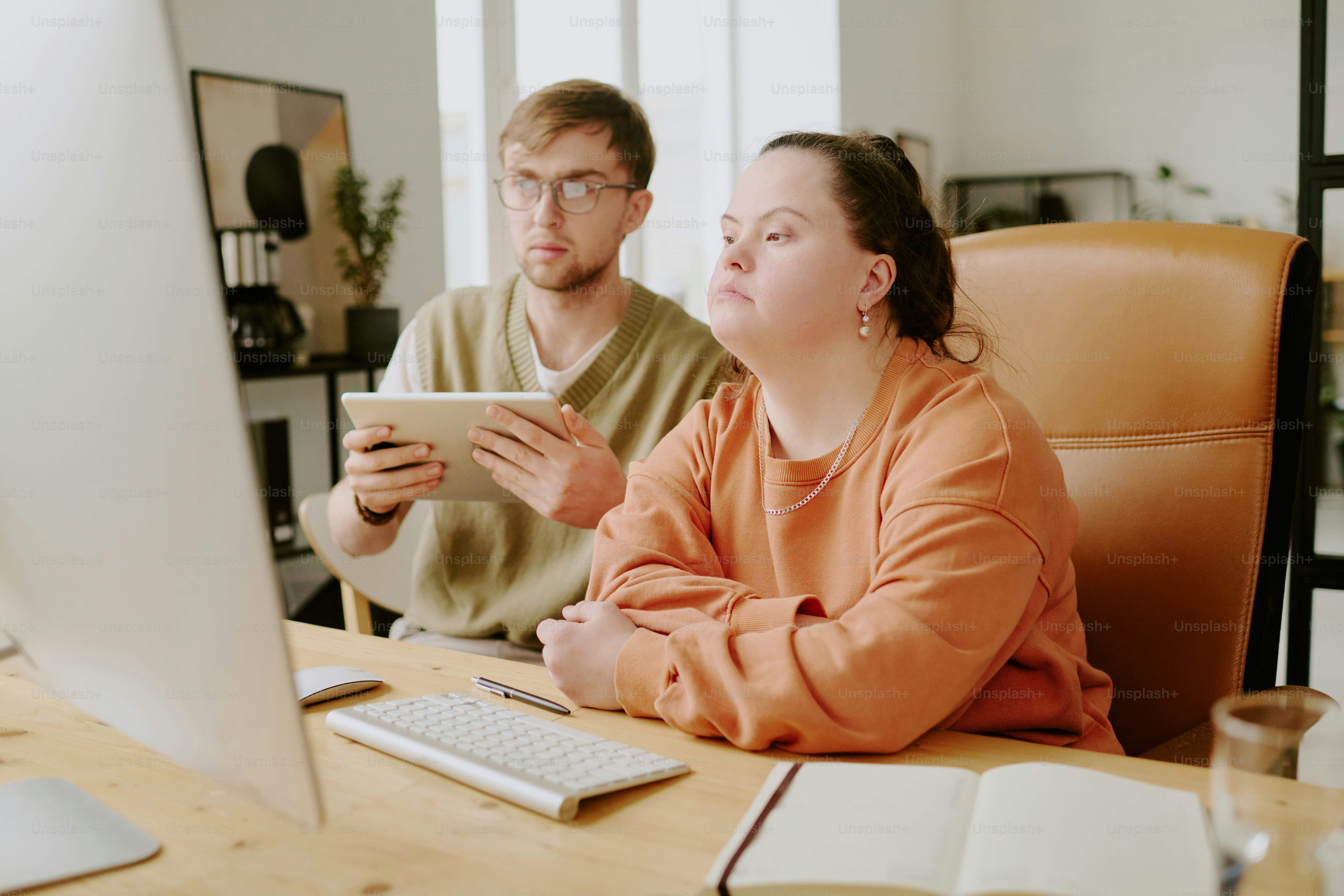 Medium close up of two highly qualified Caucasian IT specialists sitting on computers chair and working with documents together