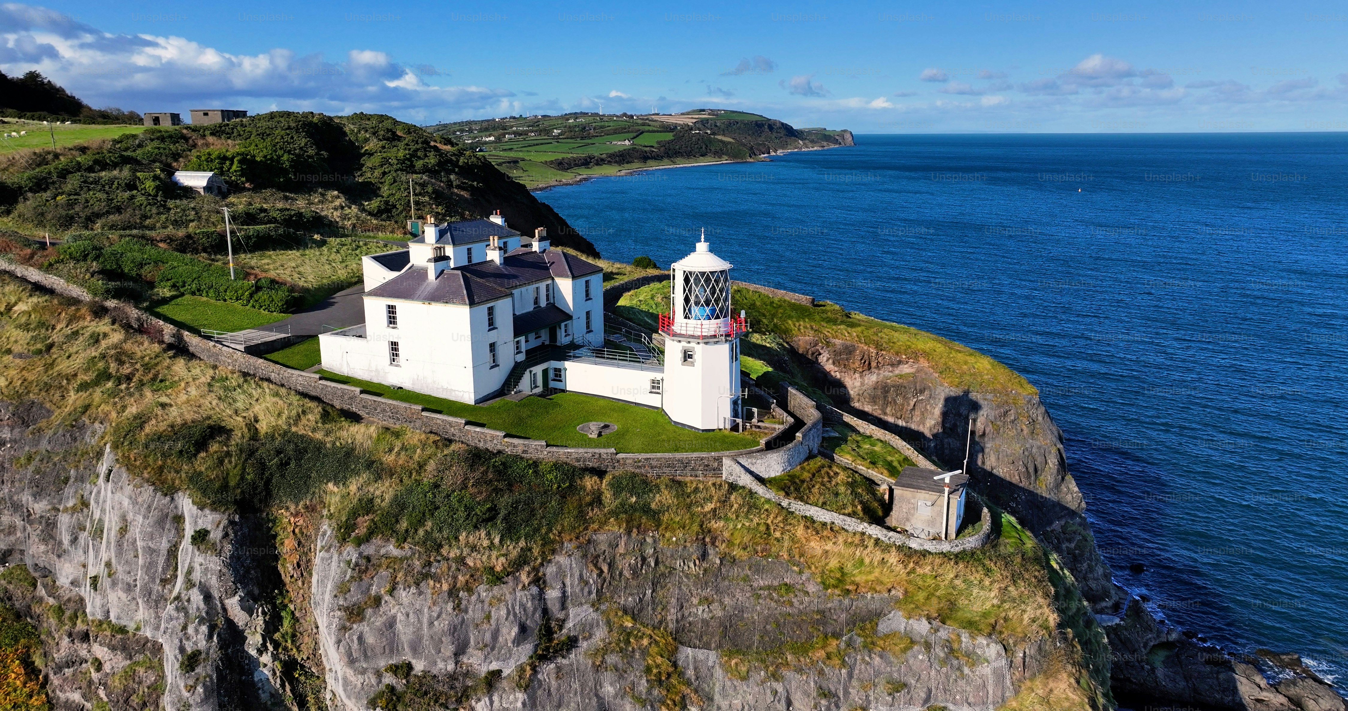 Veduta aerea del faro di Blackhead sulla bellissima e spettacolare costa delle Glens of Antrim, Irlanda del Nord