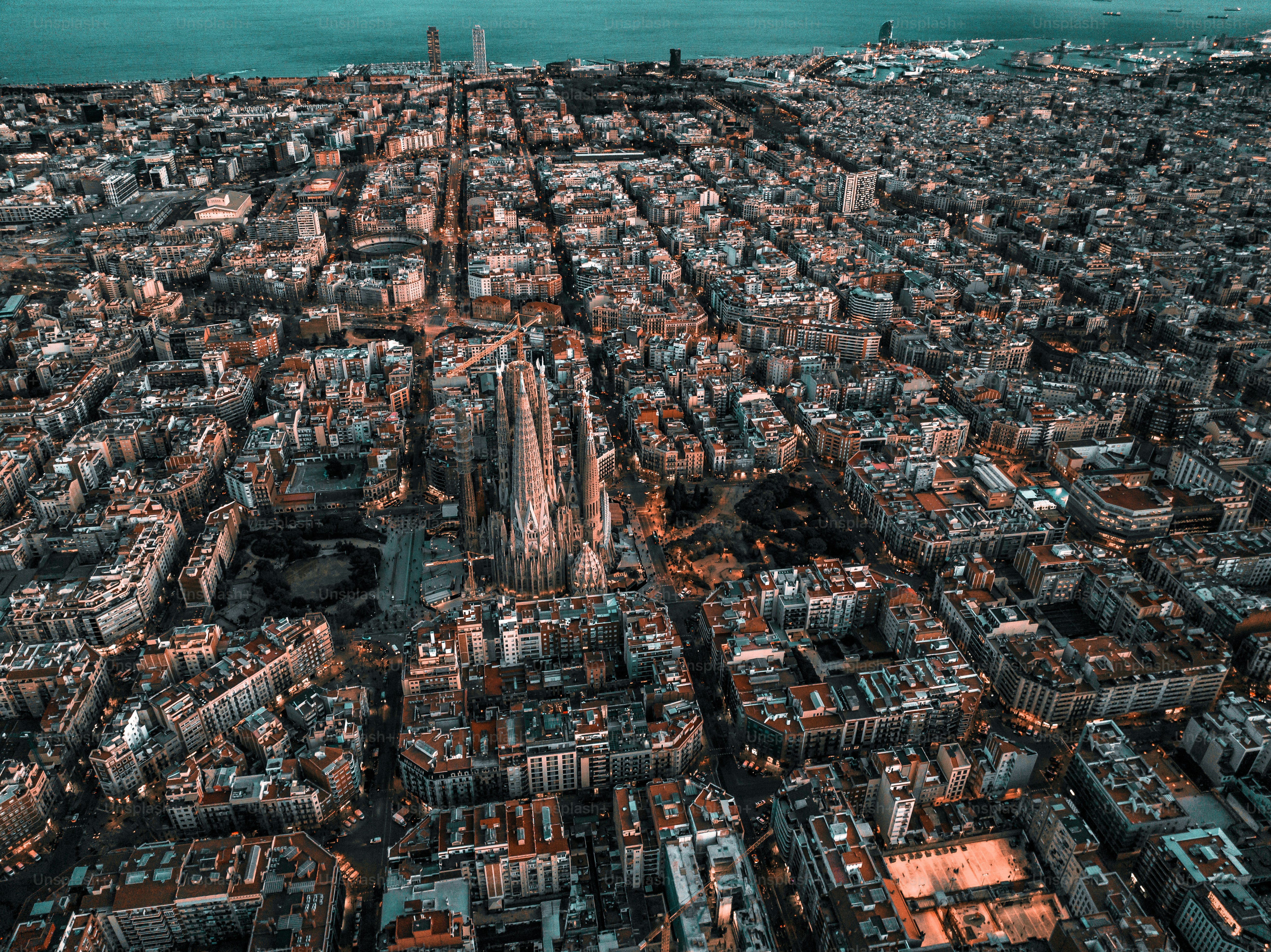 Aerial view of Barcelona City Skyline and Sagrada Familia Cathedral at sunset. Eixample residential famous urban grid. Cityscape with typical urban octagon blocks