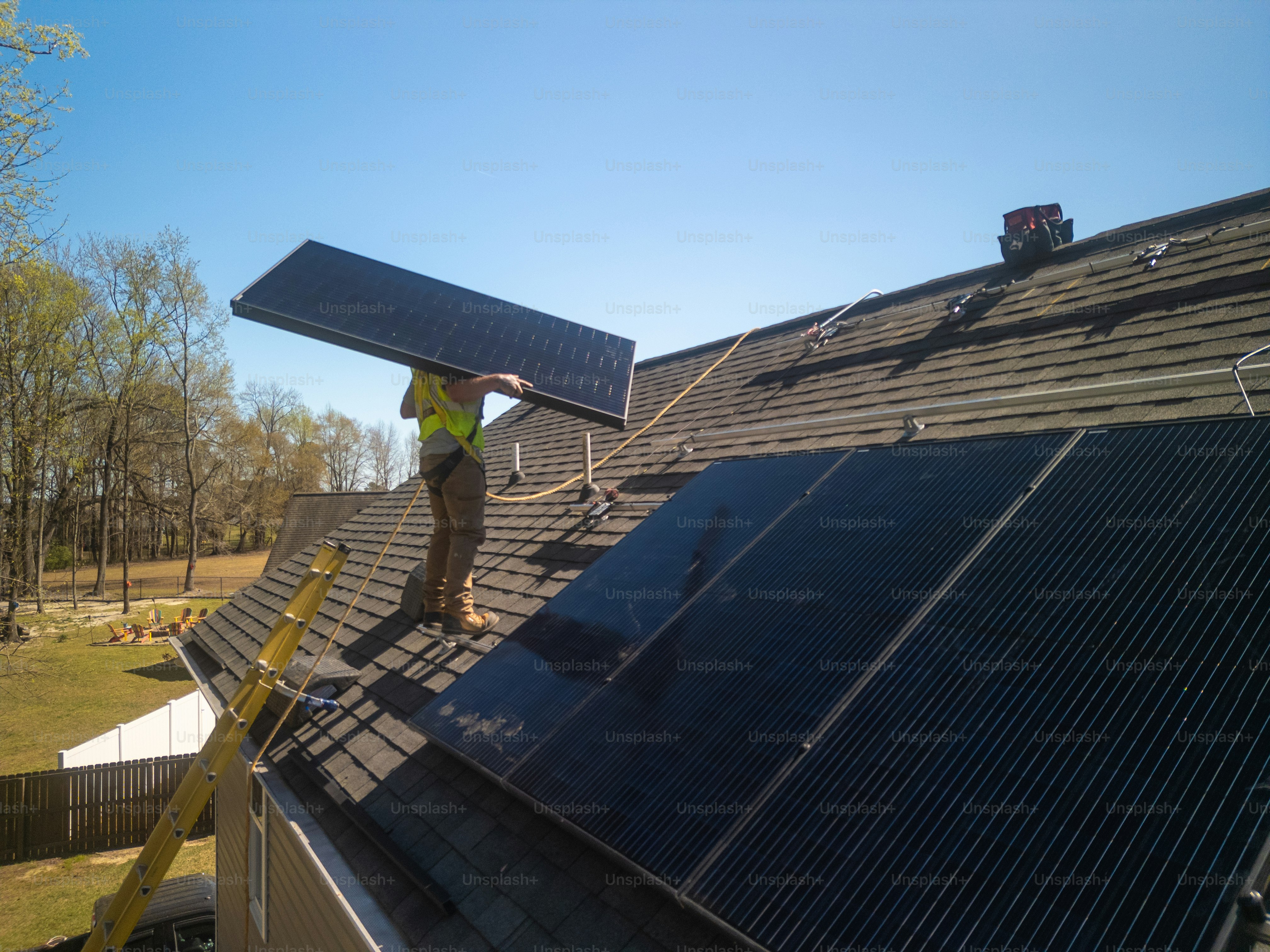 Panneaux solaires - Installation à domicile privé - Énergie durable - Rails de montage - POV de droneInstallateur de panneaux solaires - Harnais de sécurité - Maison privée - Énergie durable - Panneaux de montage - POV de drone