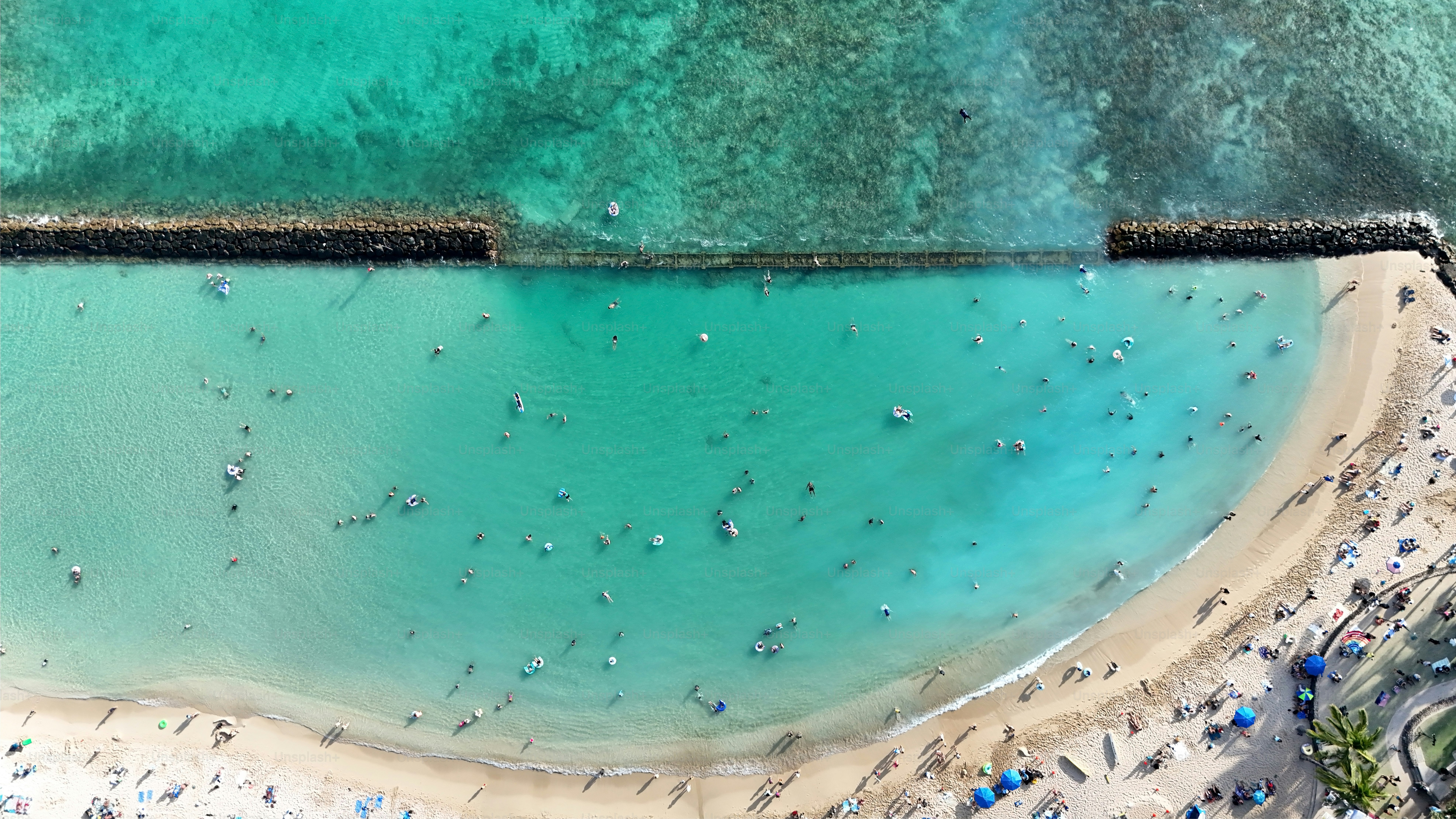 Top aerial panoramic view of beachguests and surfers waiting for some big waves on Waikiki Beach on a sunny day on O'ahu, Hawaii - USA.