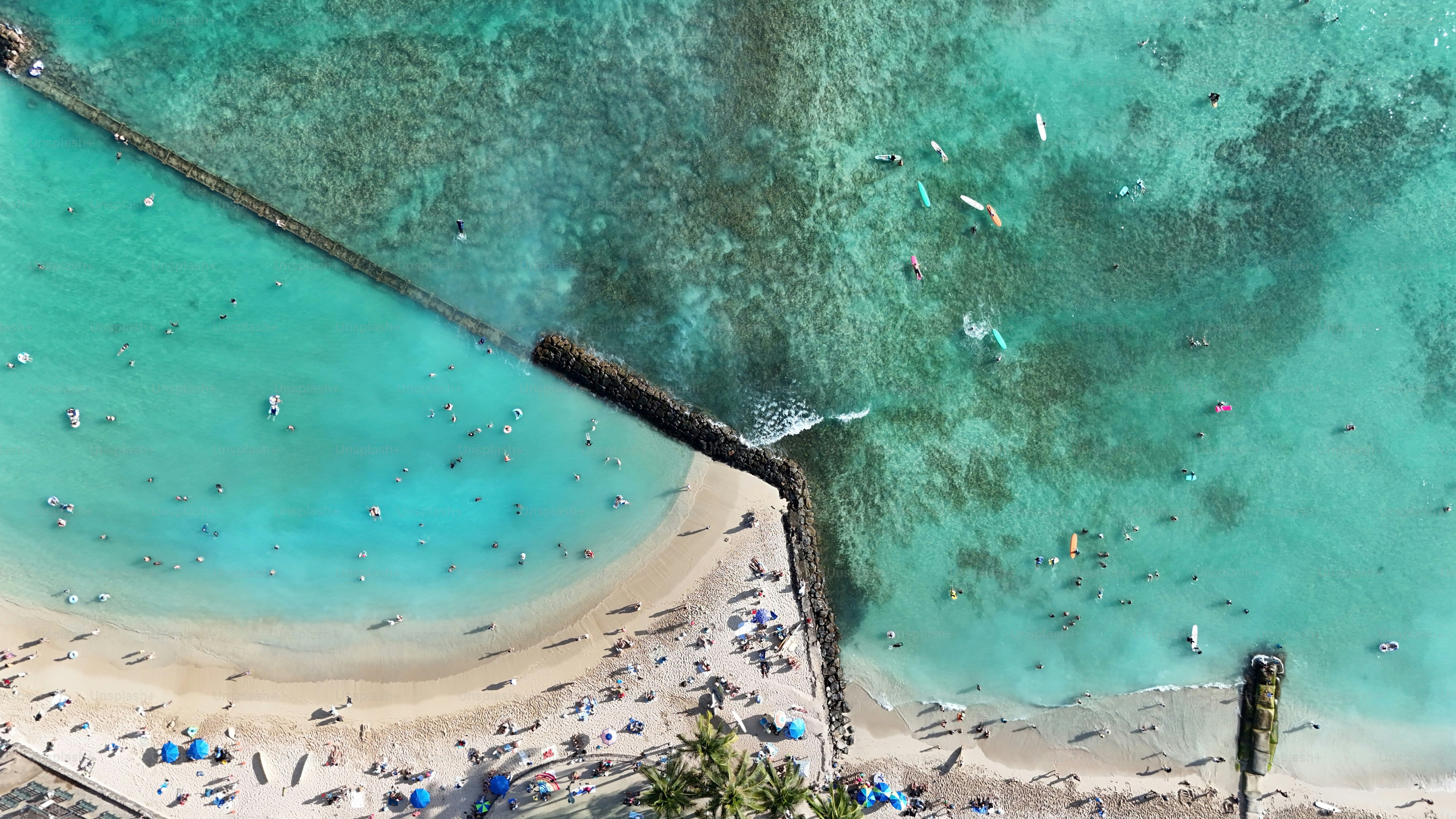 Top aerial panoramic view of beachguests and surfers waiting for some big waves on Waikiki Beach on a sunny day on O'ahu, Hawaii - USA.