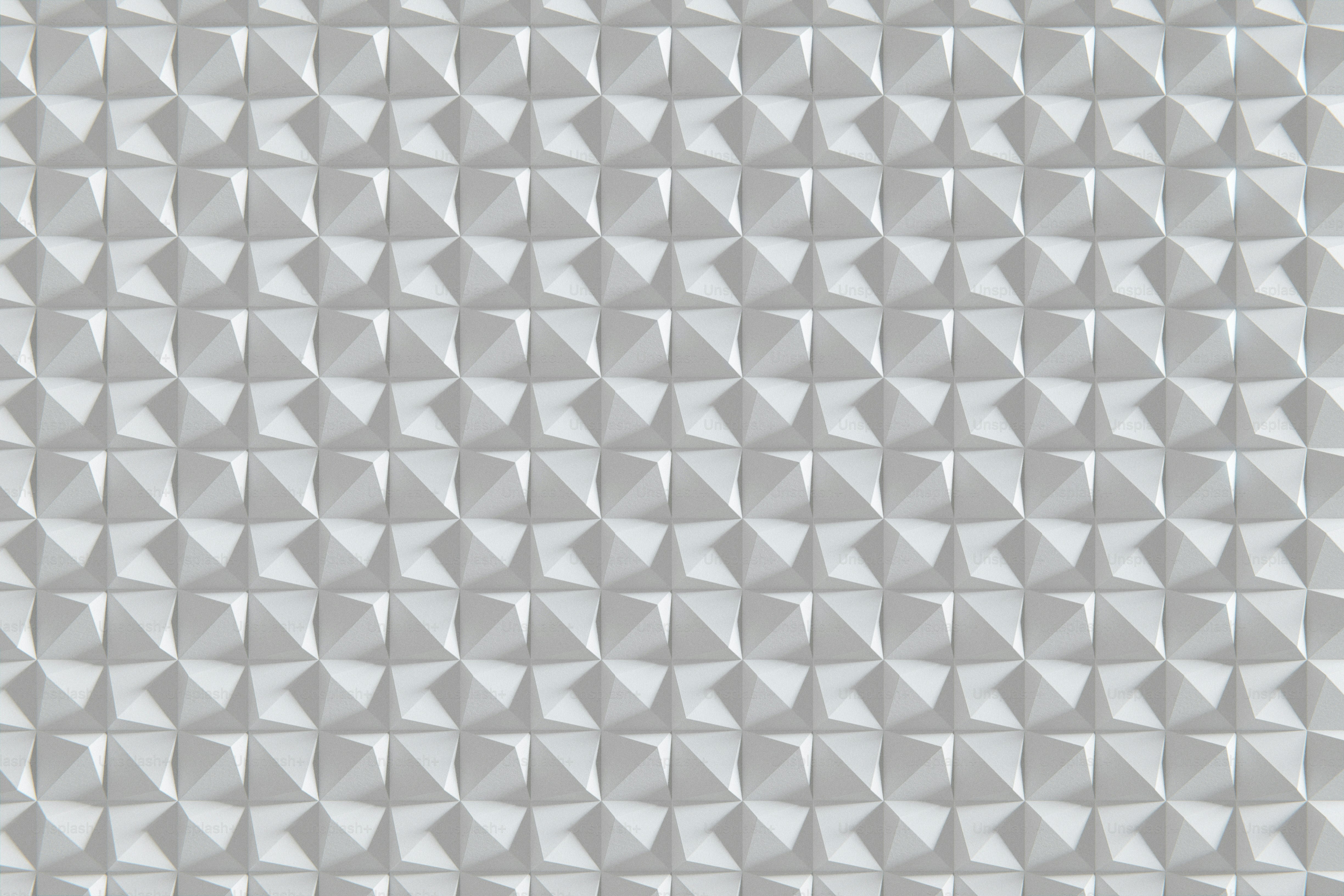 A geometric, textured white surface is shown.