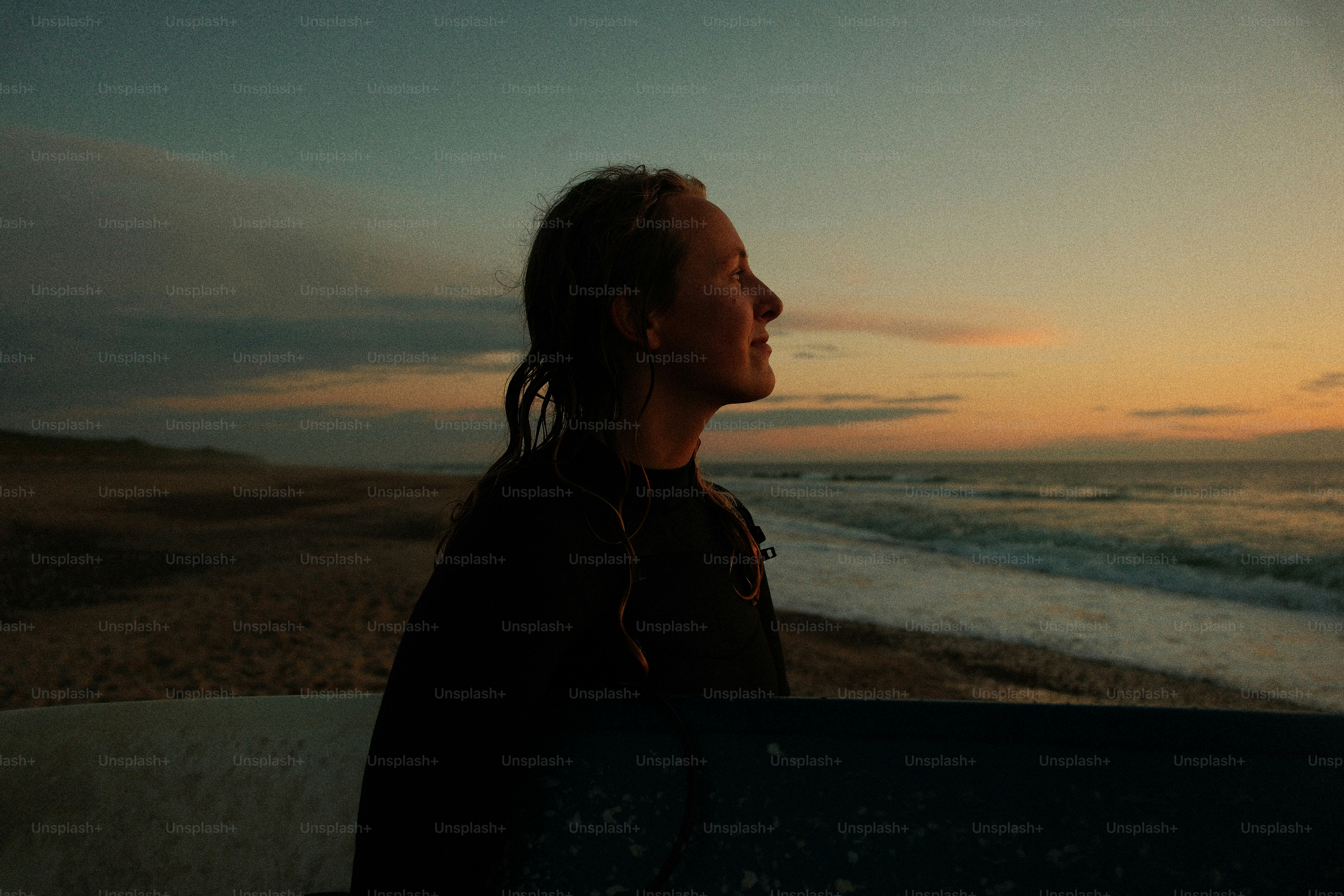 A surfer enjoys the sunset at the beach. photo – Beach Image on Unsplash